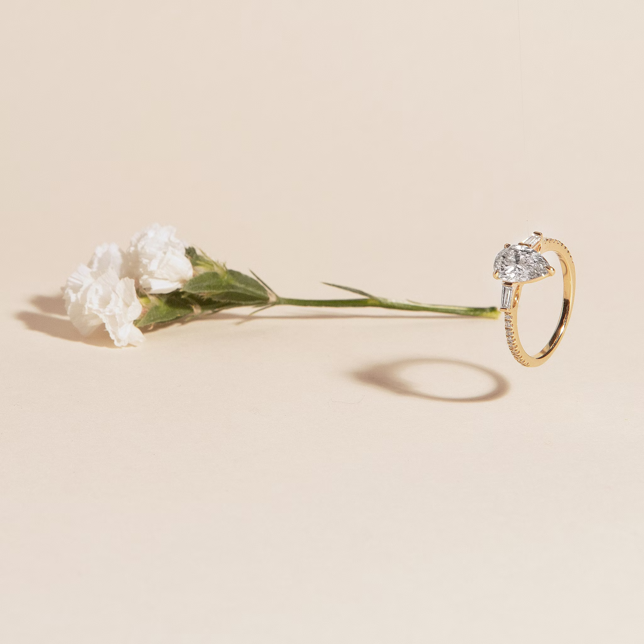 The Three Stone | Pear | 18k | Yellow Gold | bandAccent: Pavé | sideStoneCarat: 0.10ct | sideStoneShape: Tapered Baguette | diamondOrientation: vertical | caratWeight: other
