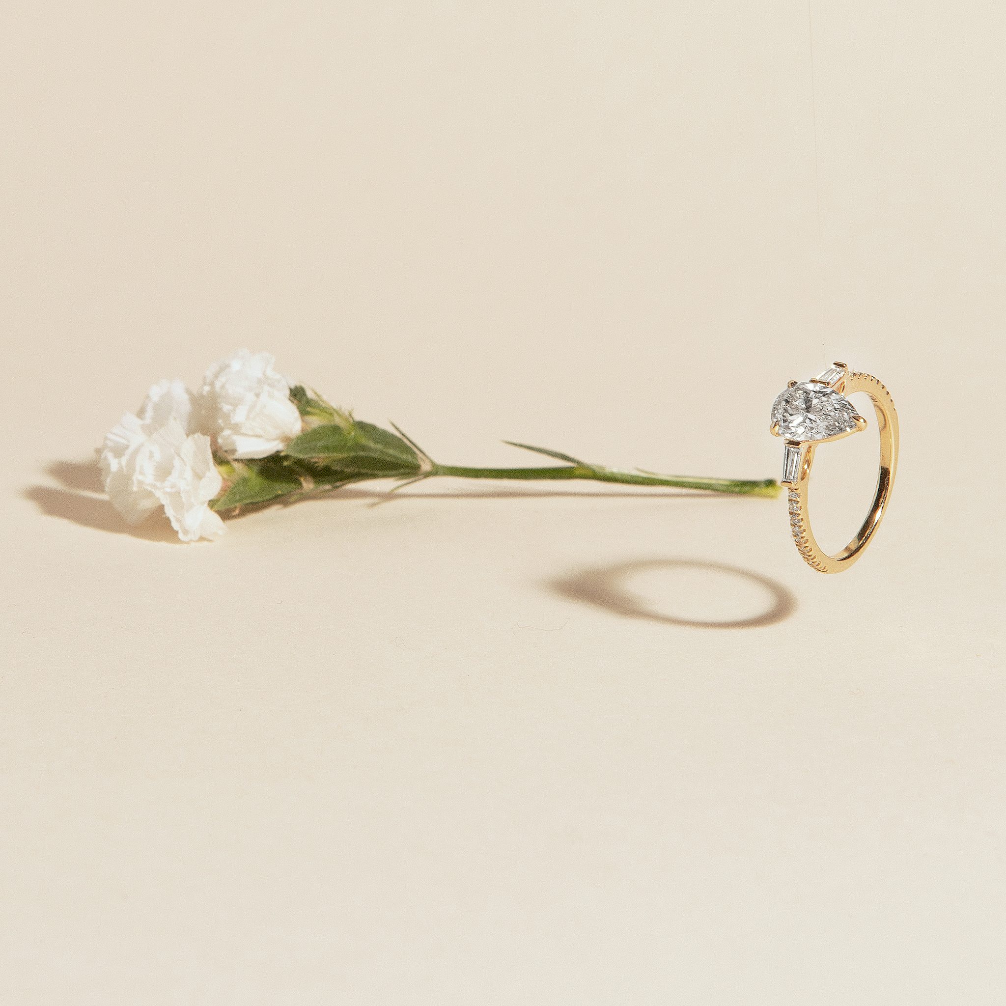 The Three Stone | Pear | 18k | Yellow Gold | bandAccent: Pavé | sideStoneCarat: 0.10ct | sideStoneShape: Tapered Baguette | diamondOrientation: vertical | caratWeight: other