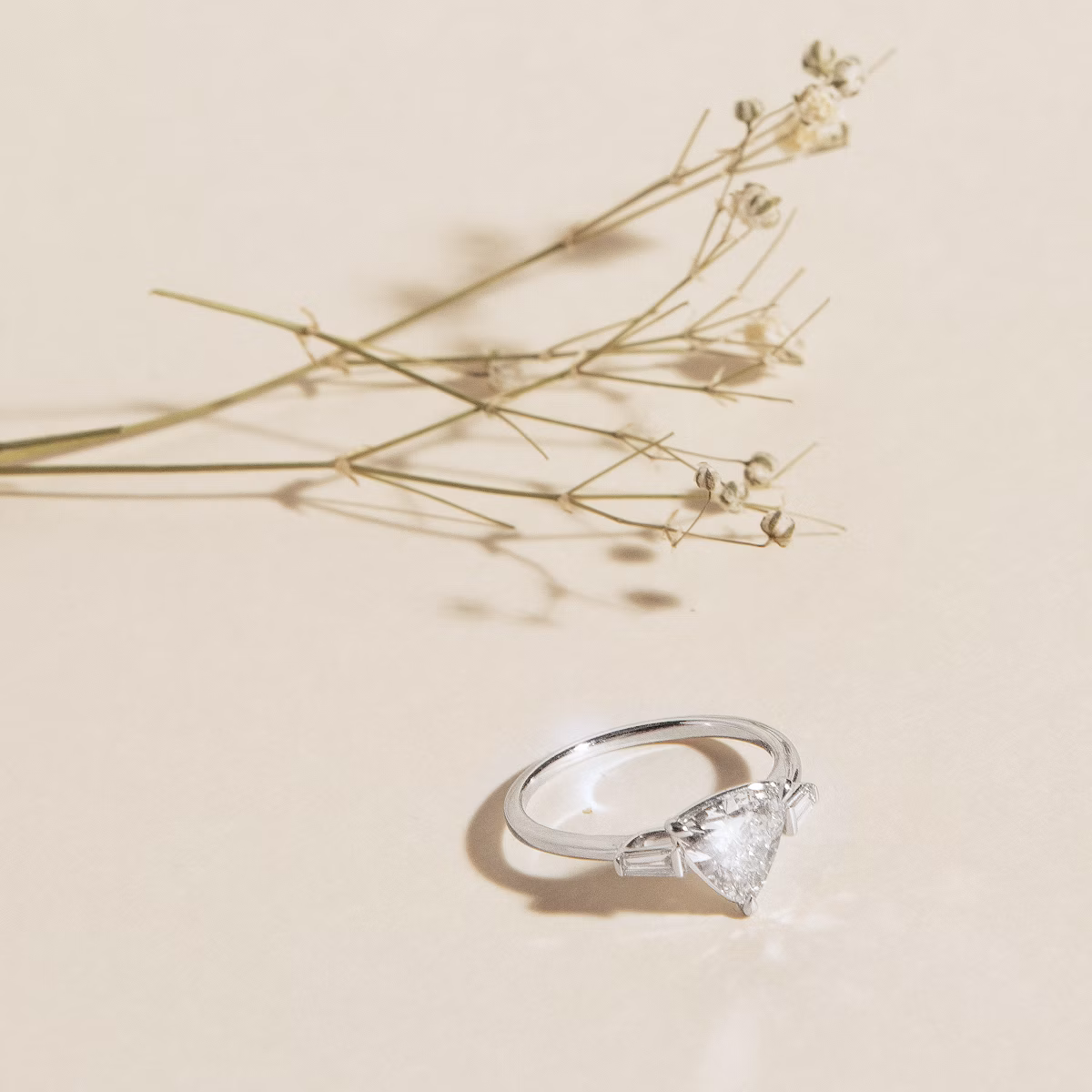 The Three Stone | Trillion | 18k | White Gold | bandAccent: Plain | sideStoneCarat: 0.10ct | sideStoneShape: Tapered Baguette | diamondOrientation: vertical | caratWeight: other