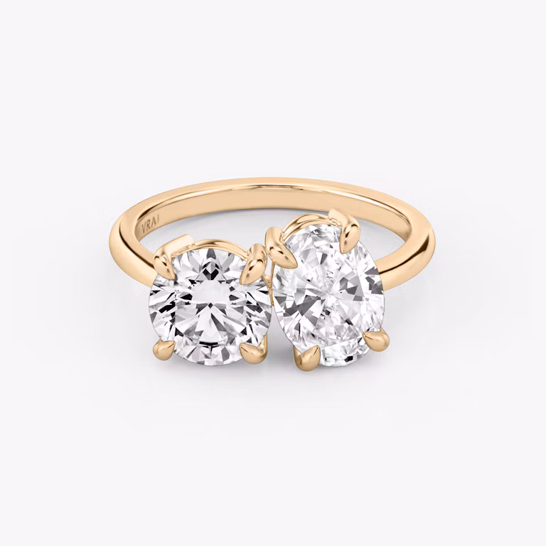 Front view of the Toi et Moi ring in rose gold with round brilliant and oval-cut diamonds on a white background.