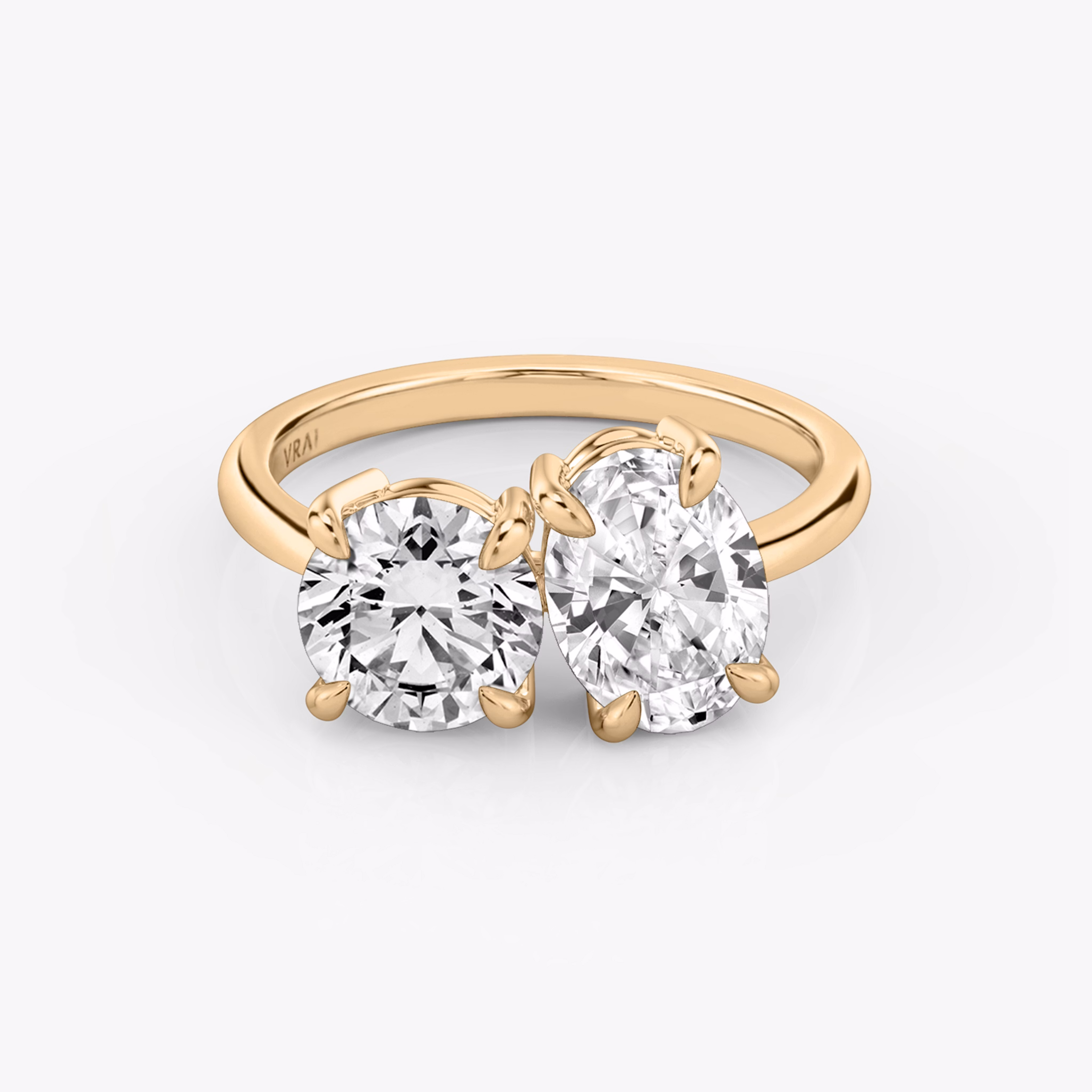 Front view of the Toi et Moi ring in rose gold with round brilliant and oval-cut diamonds on a white background.
