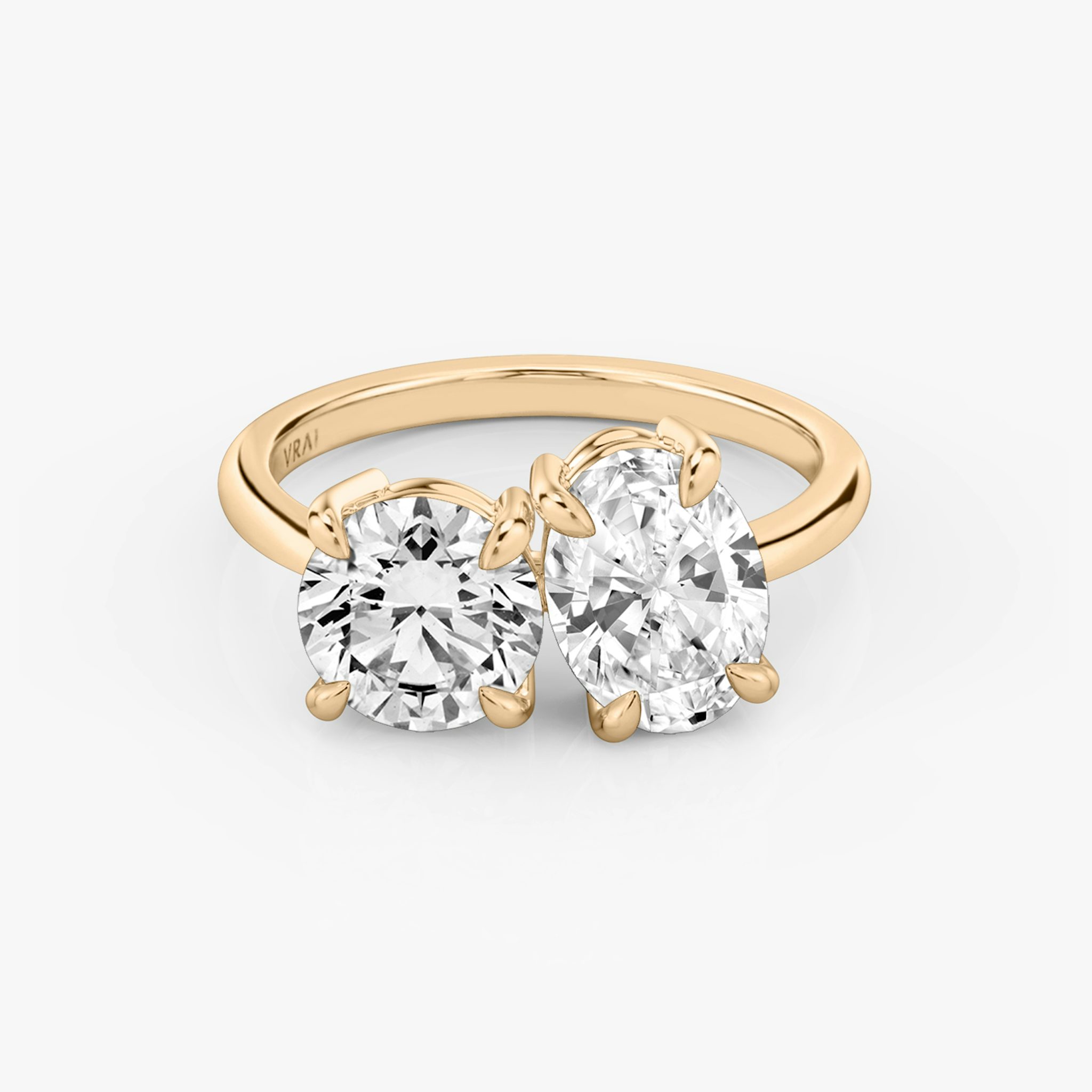 Front view of the Toi et Moi ring in rose gold with round brilliant and oval-cut diamonds on a white background.