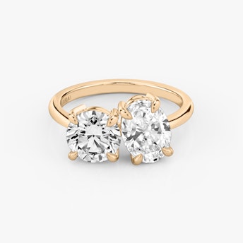 Front view of the Toi et Moi ring in rose gold with round brilliant and oval-cut diamonds on a white background.