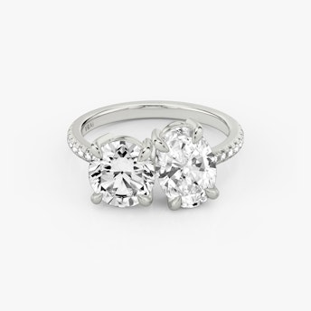 A Toi et Moi-style engagement ring with a white gold band.