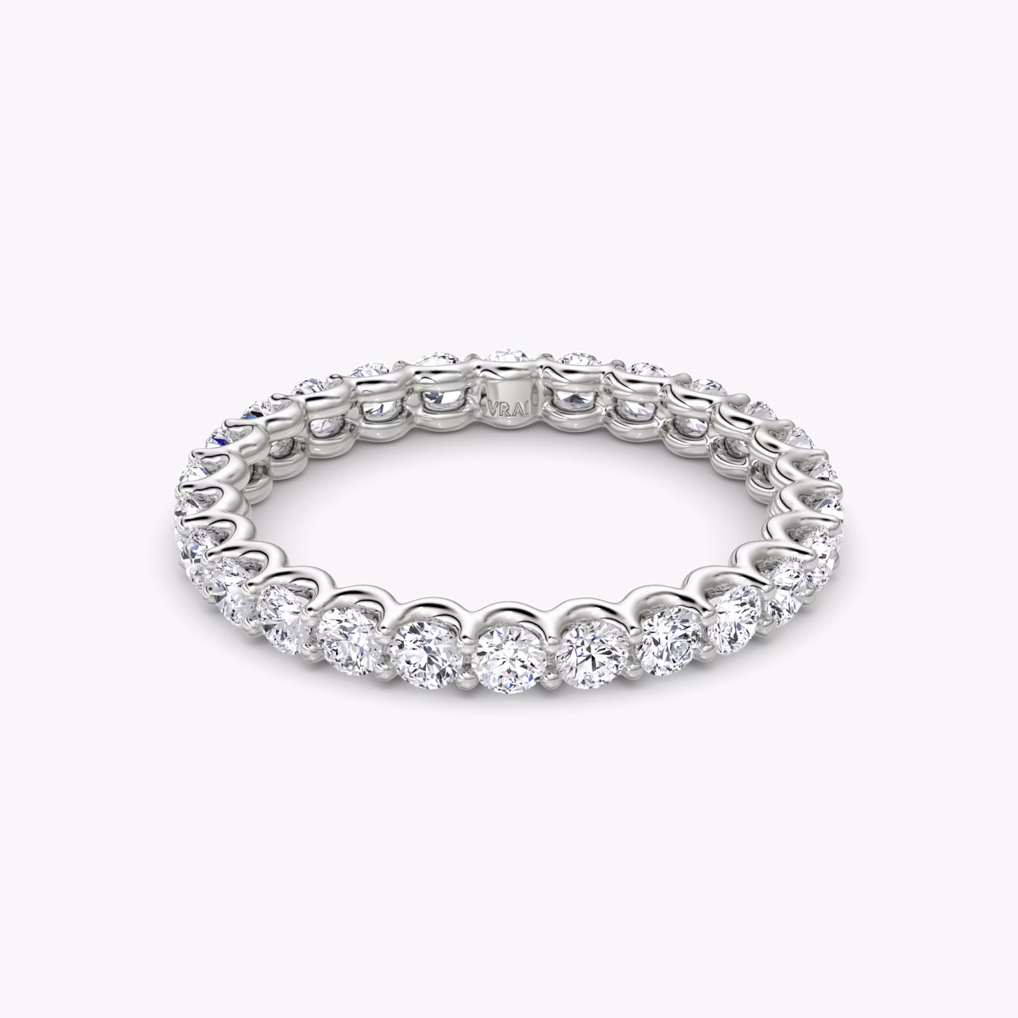 Platinum eternity band with round brilliant-cut diamonds in a scalloped setting, shown on white background.