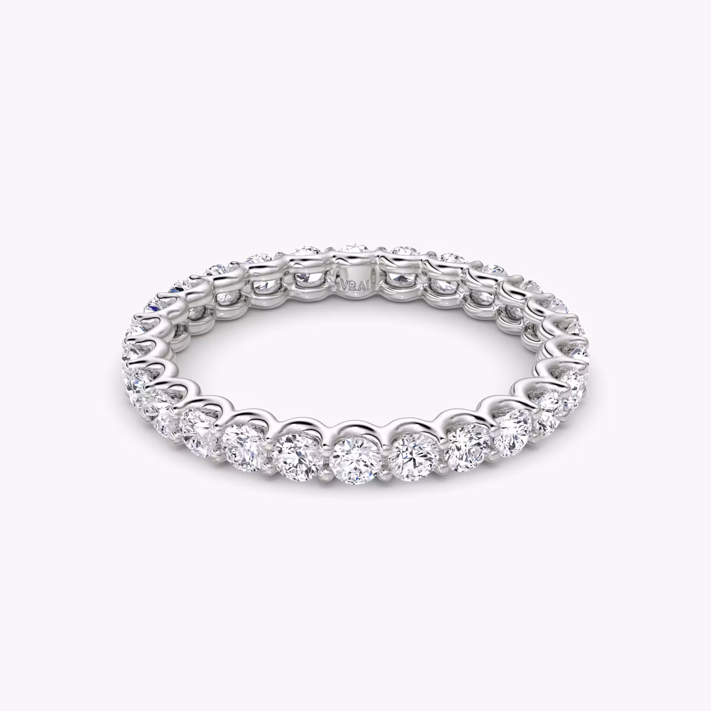 Platinum eternity band with round brilliant-cut diamonds in a scalloped setting, shown on white background.