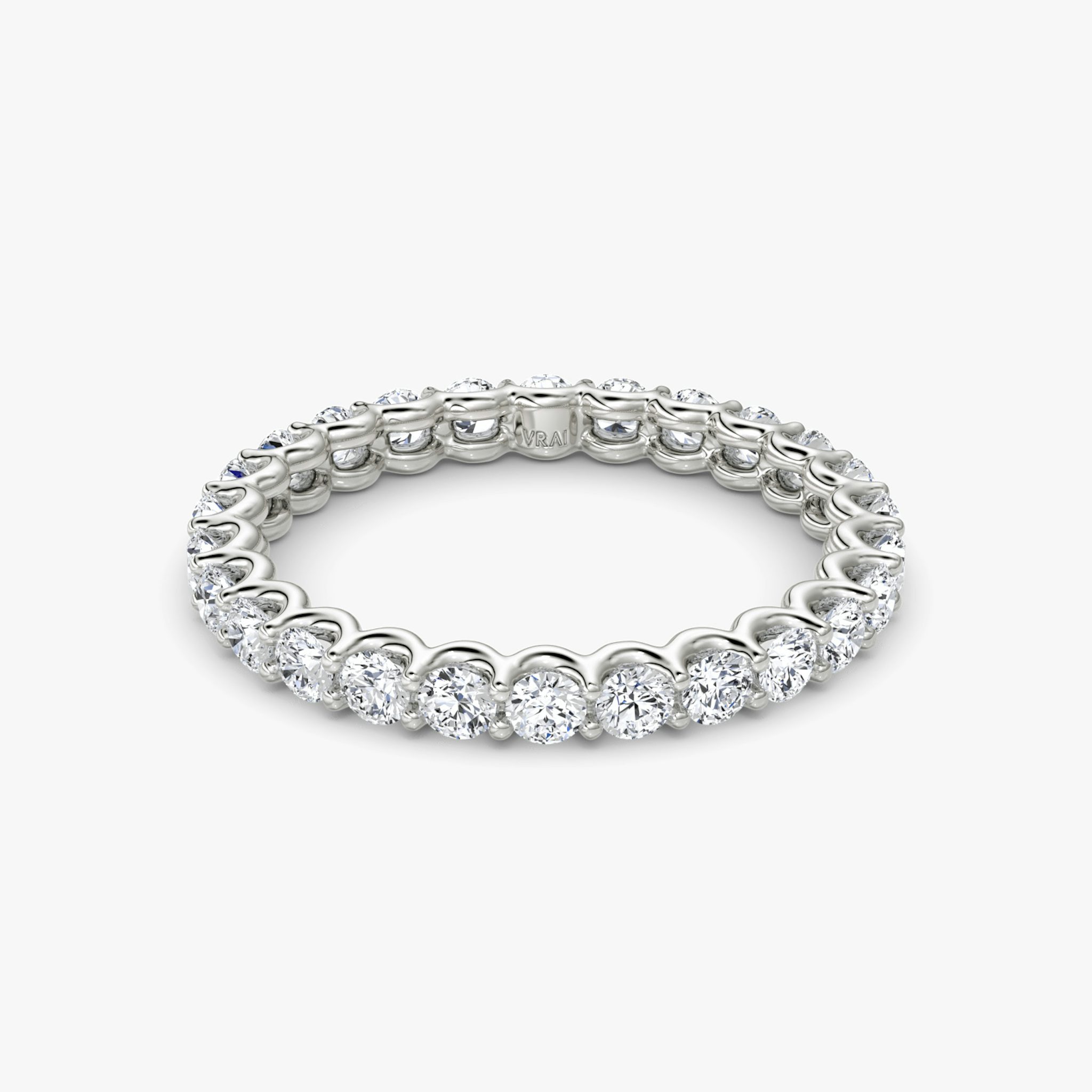 Platinum eternity band with round brilliant-cut diamonds in a scalloped setting, shown on white background.