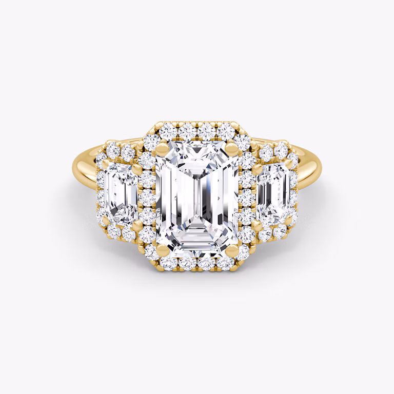 The Three Stone Halo Emerald Yellow Gold Engagement Ring.