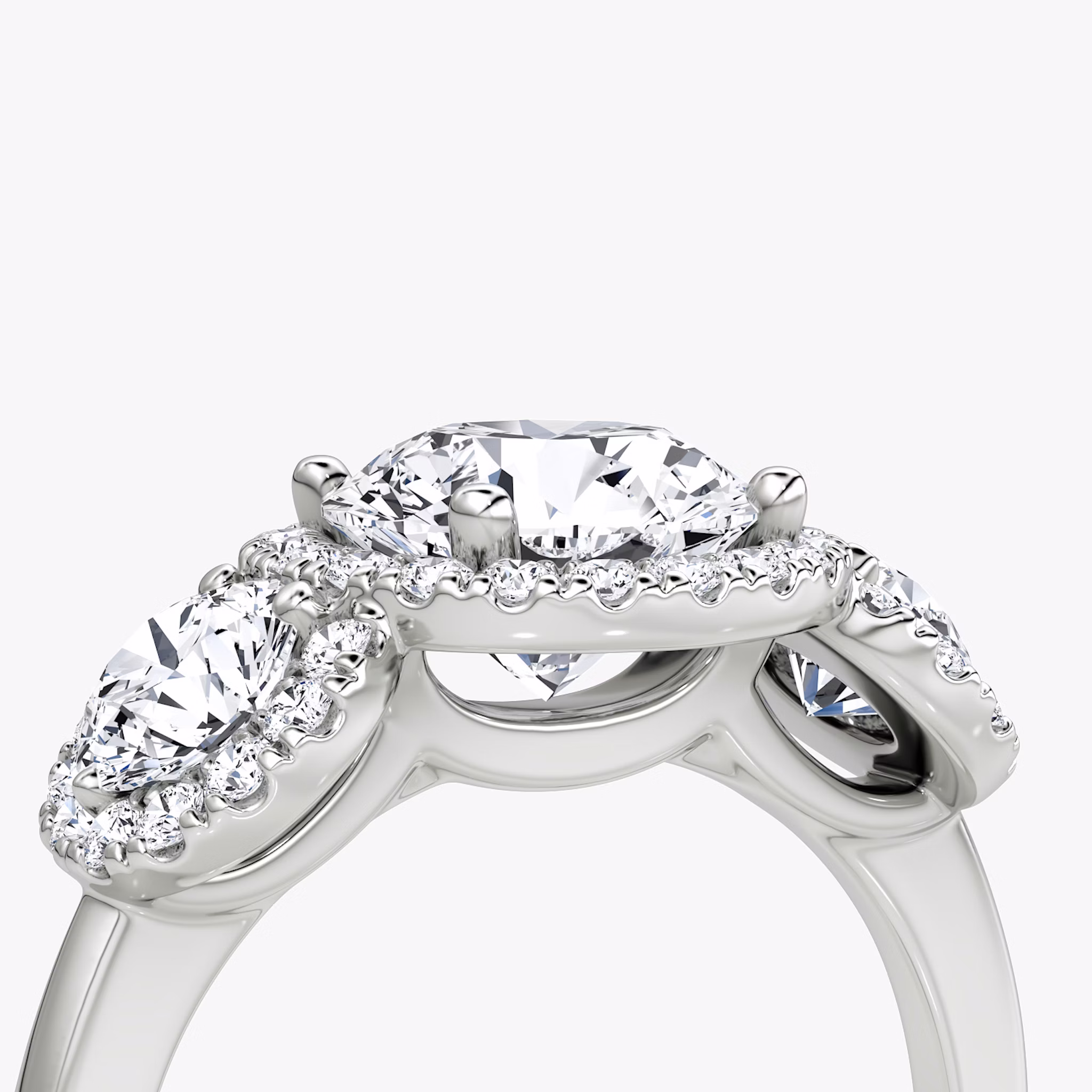 The Three Stone Halo | Round Brilliant | 18k | White Gold | bandAccent: Plain | caratWeight: other | sideStoneCarat: 0.25ct | diamondOrientation: vertical