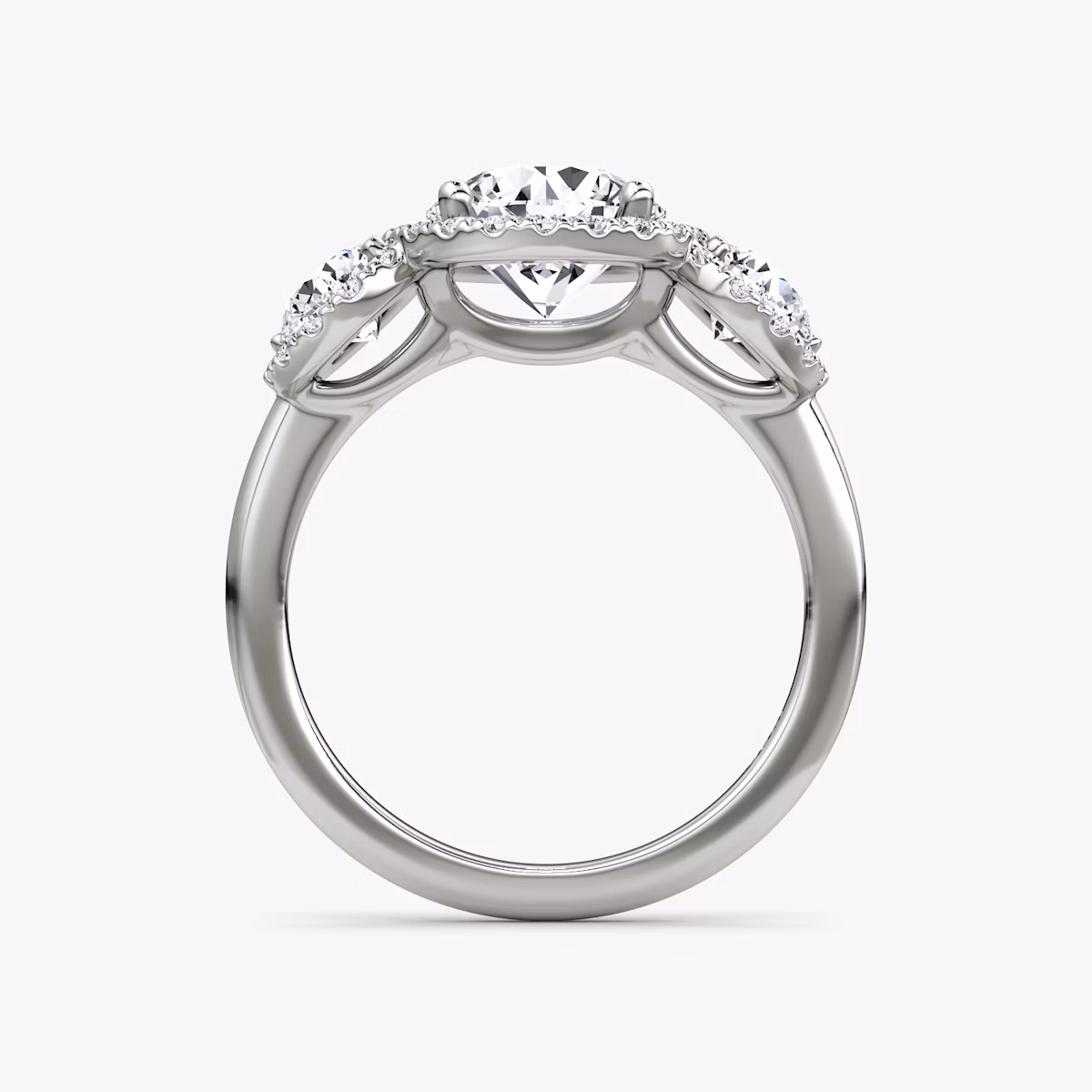 The Three Stone Halo | Round Brilliant | Platinum | bandAccent: Plain | caratWeight: other | sideStoneCarat: 0.25ct | diamondOrientation: vertical