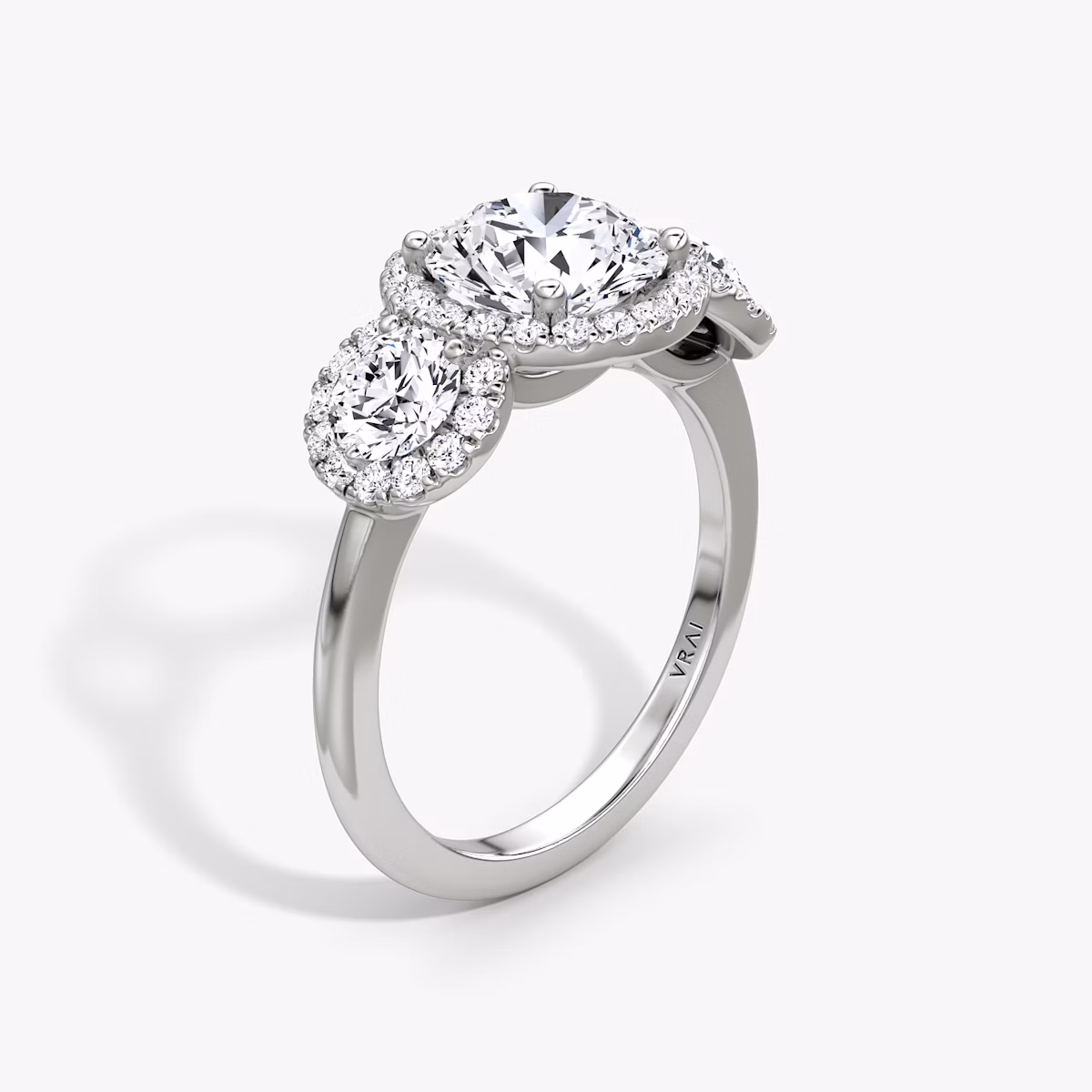 The Three Stone Halo | Round Brilliant | Platinum | bandAccent: Plain | caratWeight: other | sideStoneCarat: 0.25ct | diamondOrientation: vertical