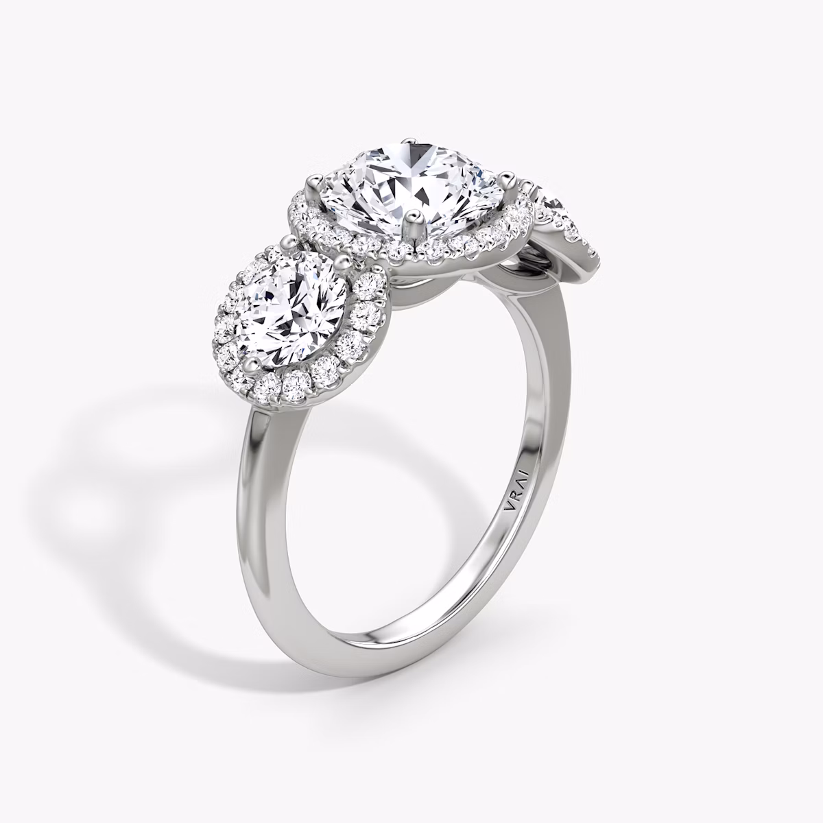 The Three Stone Halo | Round Brilliant | Platinum | bandAccent: Plain | caratWeight: 1.0ct | sideStoneCarat: 0.50ct | diamondOrientation: vertical