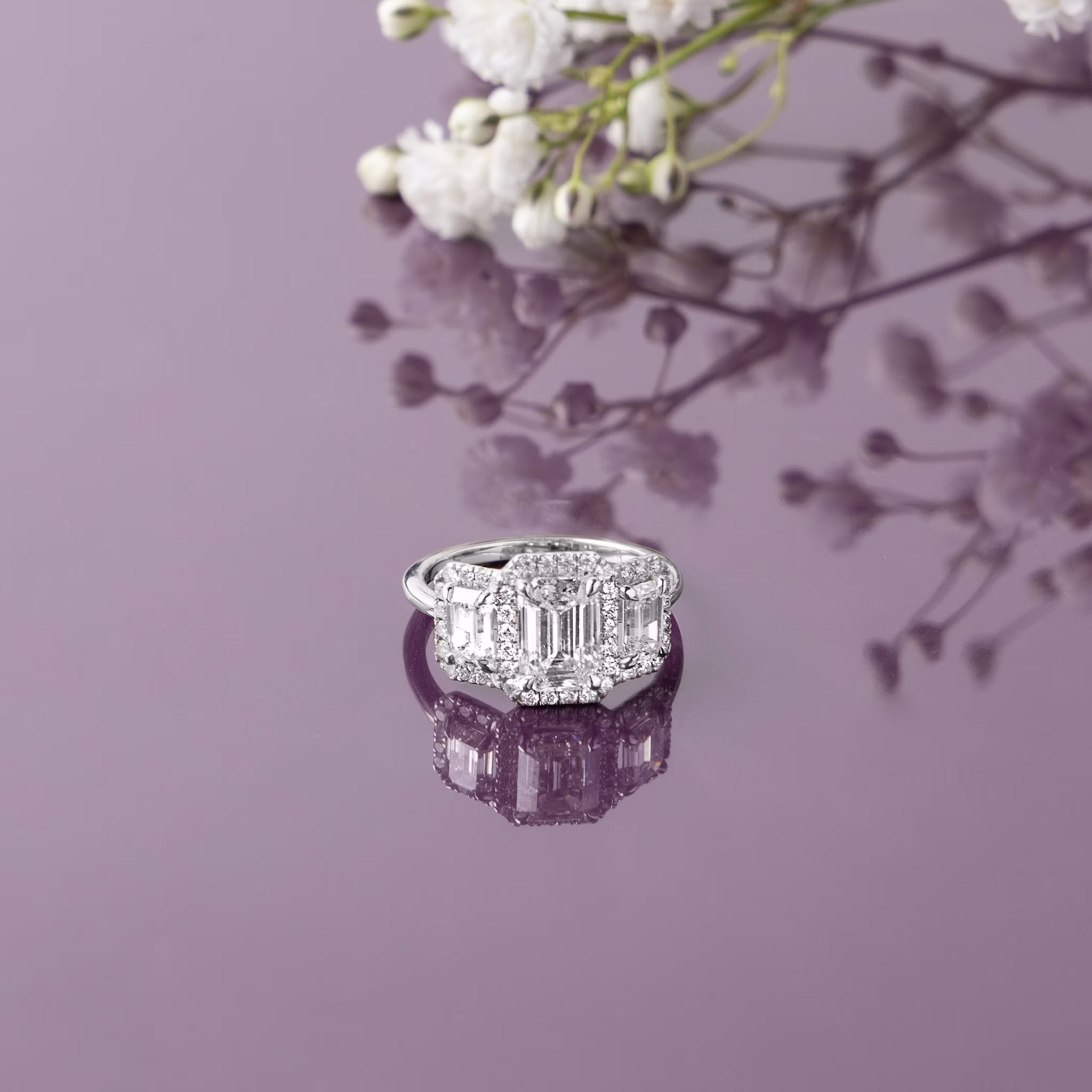 The Three Stone Halo | Emerald | 14k | Rose Gold | bandAccent: Plain | sideStoneCarat: 0.25ct | diamondOrientation: vertical | caratWeight: other