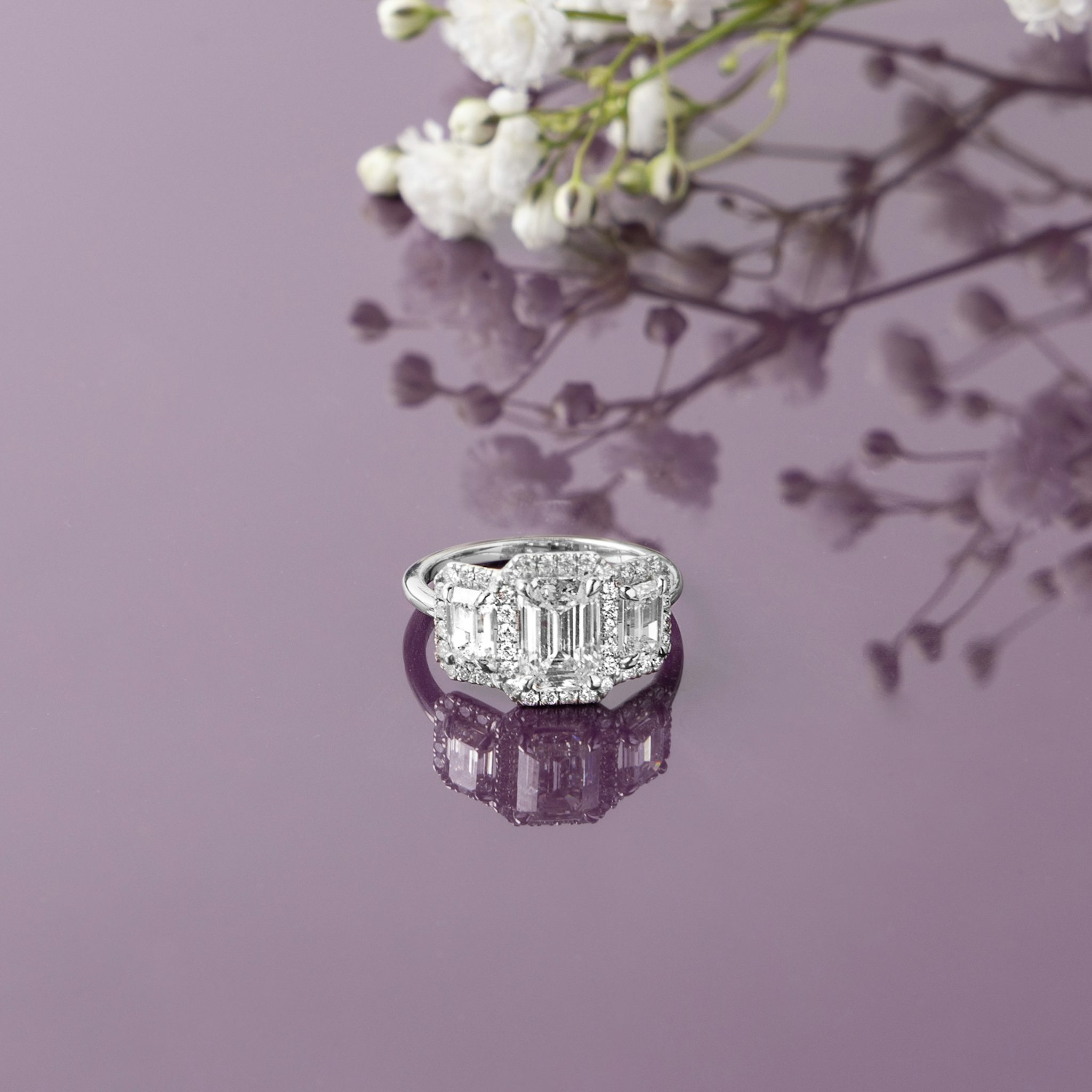 The Three Stone Halo | Emerald | 14k | Rose Gold | bandAccent: Plain | sideStoneCarat: 0.25ct | diamondOrientation: vertical | caratWeight: other