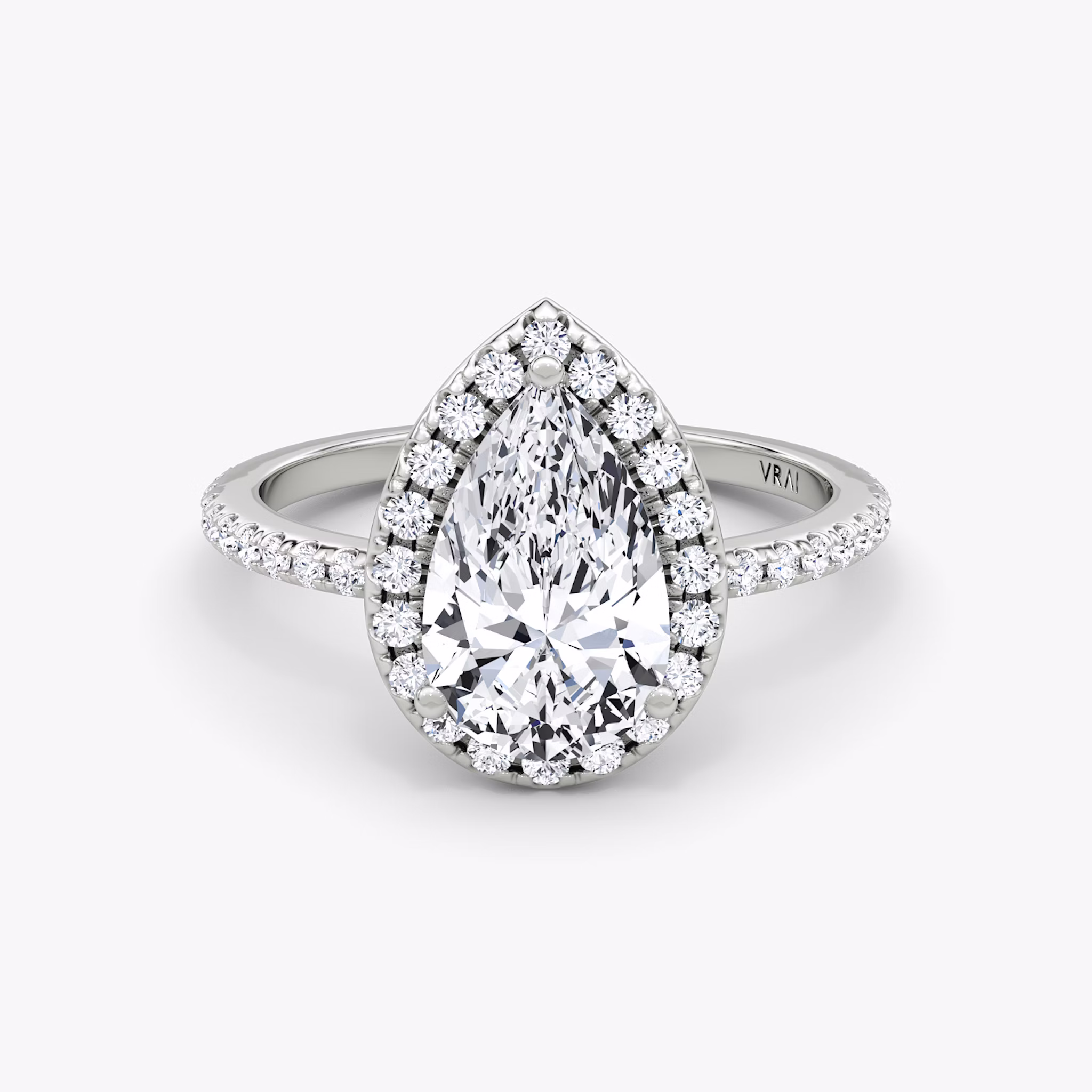 White gold pavé ring with pear-cut center diamond and halo setting, shown on white background.