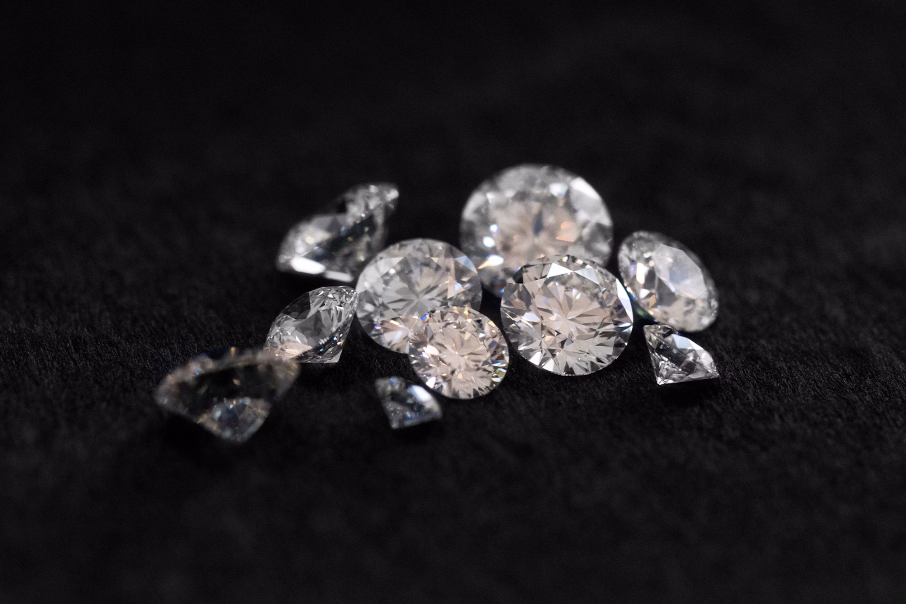 Multiple Round Brilliant cut diamonds on a black background.