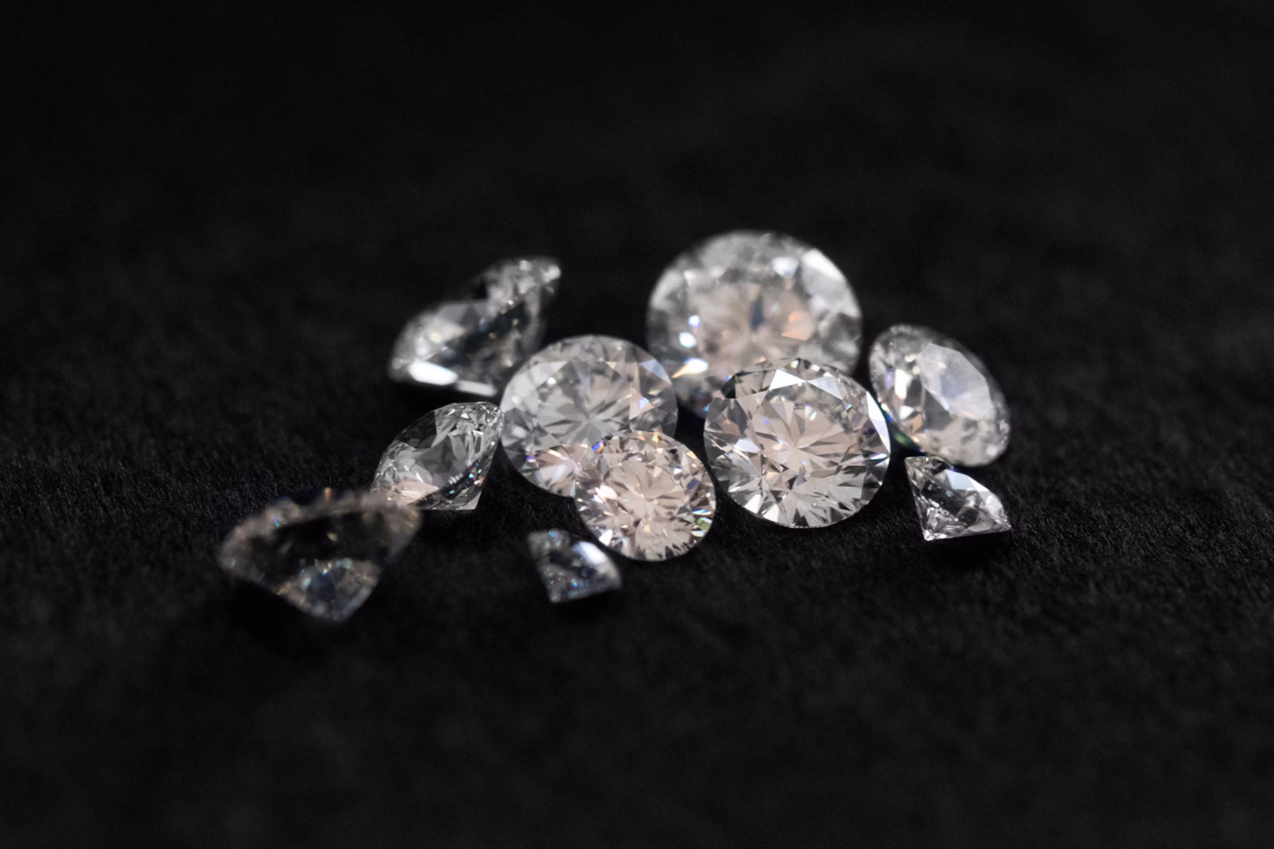 Multiple Round Brilliant cut diamonds on a black background.