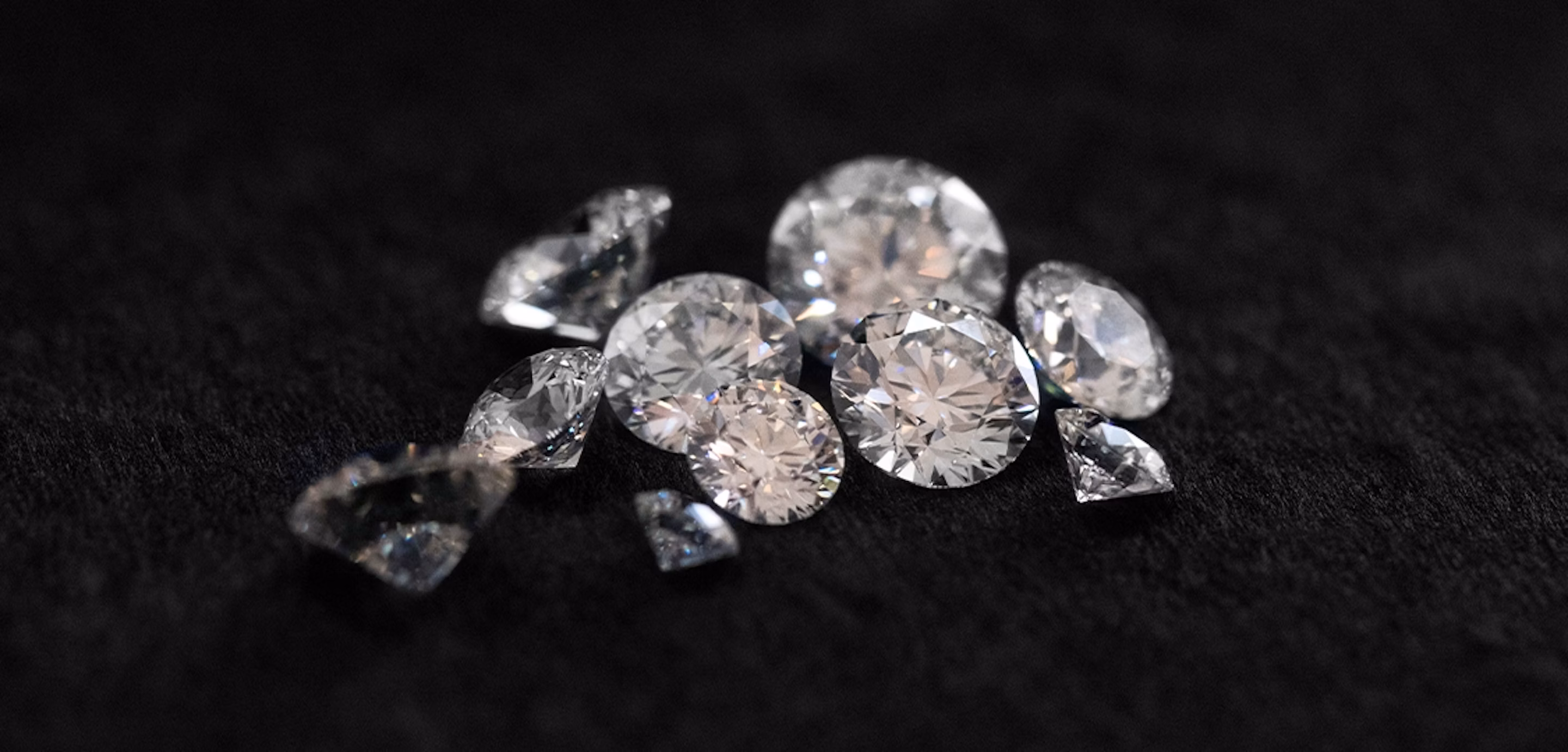 Multiple Round Brilliant cut diamonds on a black background.