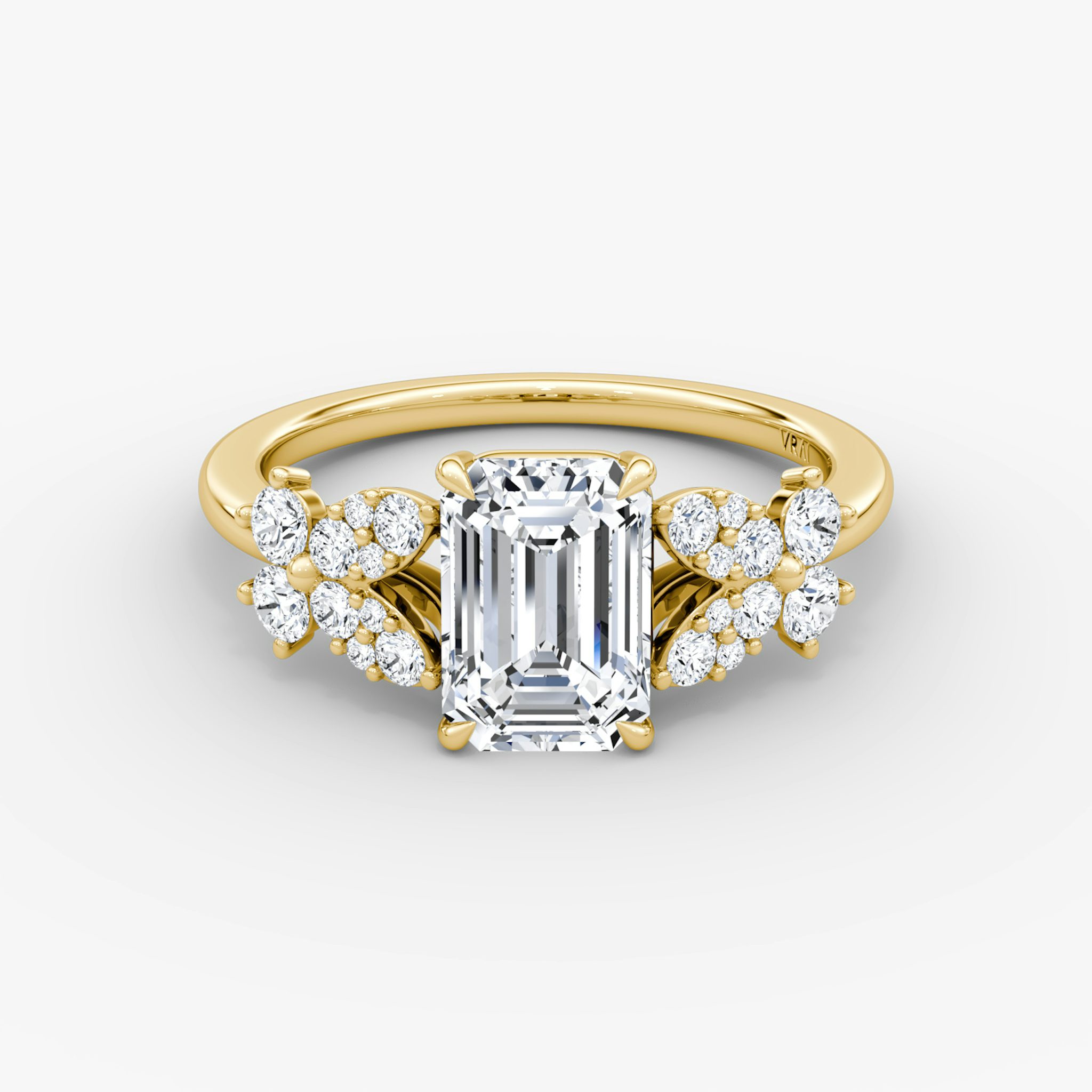 Front view of a signature floral emerald engagement ring in plain yellow gold on a white background.