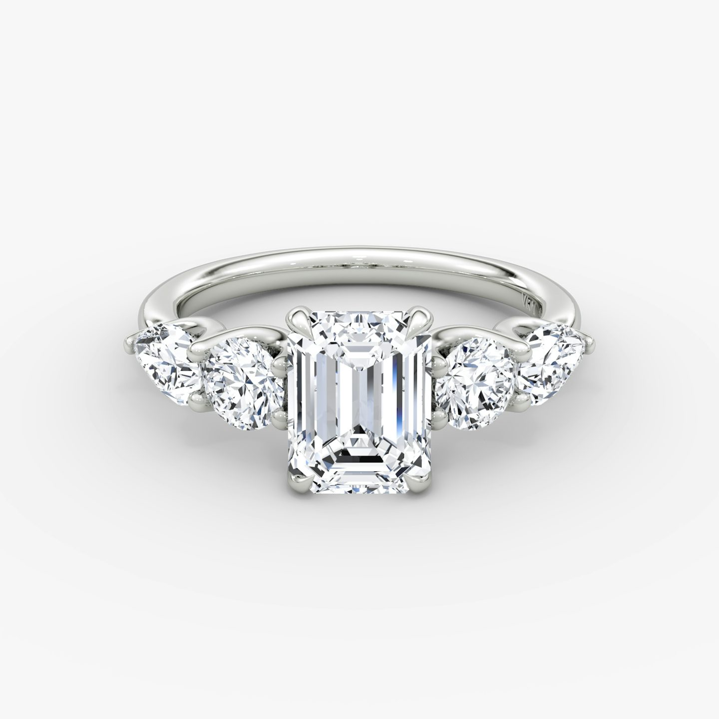 The Mixed Shape | Emerald | Platinum | bandAccent: Plain | sideStoneOrientation: horizontal | sideStoneShape: Round Brilliant and Pear | diamondOrientation: vertical | caratWeight: other