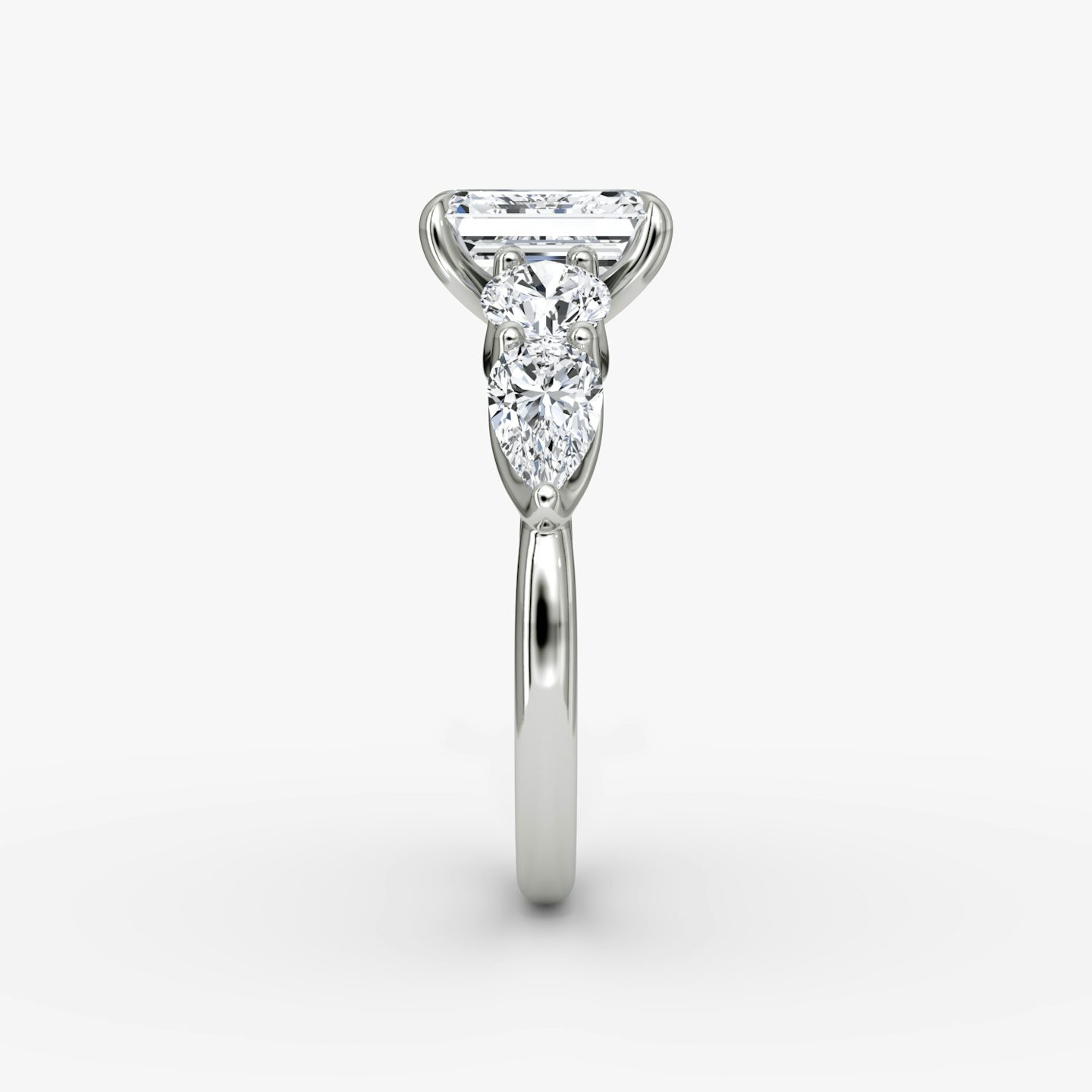The Mixed Shape | Emerald | Platinum | bandAccent: Plain | sideStoneOrientation: horizontal | sideStoneShape: Round Brilliant and Pear | diamondOrientation: vertical | caratWeight: other