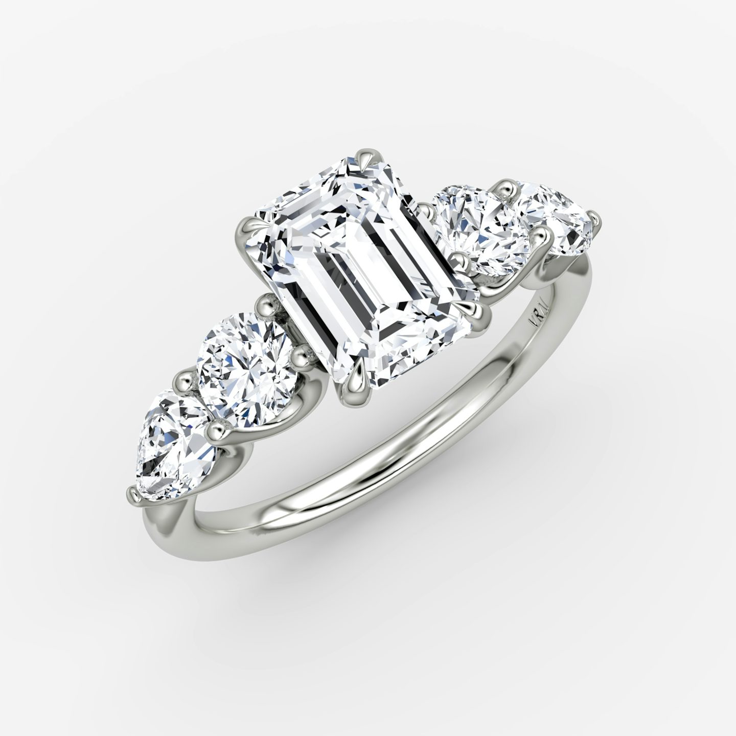 The Mixed Shape | Emerald | Platinum | bandAccent: Plain | sideStoneOrientation: horizontal | sideStoneShape: Round Brilliant and Pear | diamondOrientation: vertical | caratWeight: other