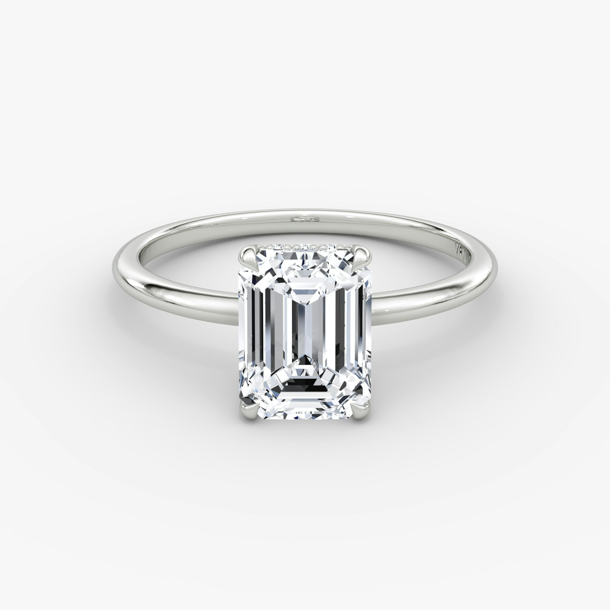 Emerald-cut diamond engagement ring with pavé halo on a thin platinum band, VRAI Signature Prong style.