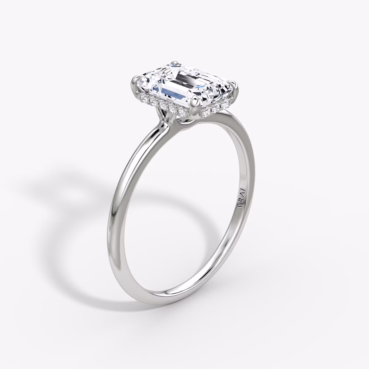 Emerald-cut signature diamond engagement ring with hidden halo on a plain platinum band, VRAI Signature Prong style.