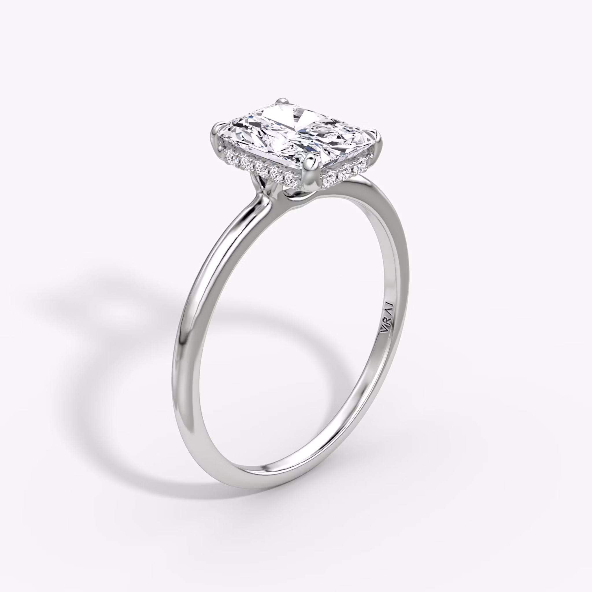 Radiant-cut diamond ring with hidden halo and plain platinum band, VRAI Signature Hidden Halo setting.