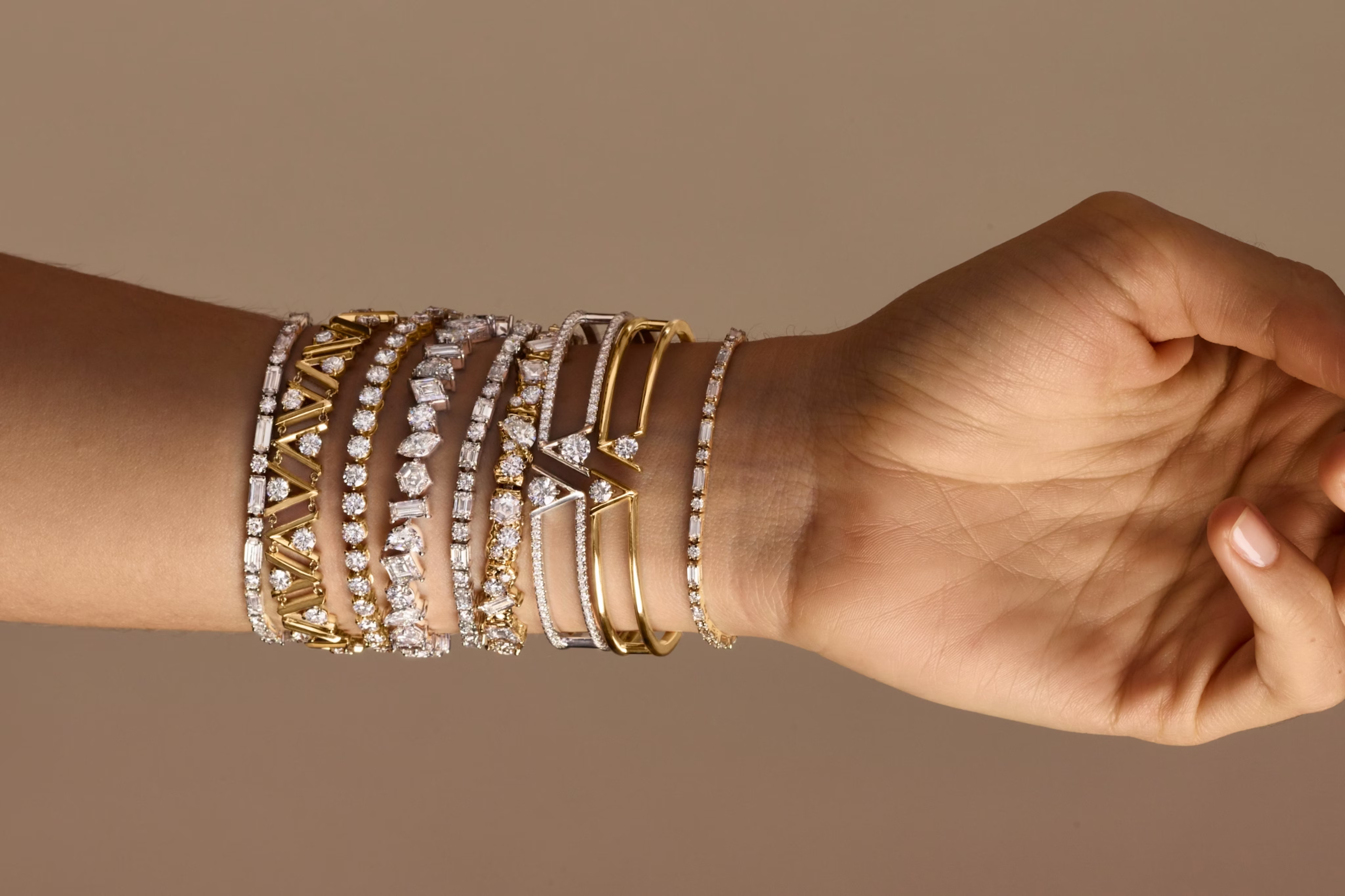 A wrist with multiple types of bracelets on it.