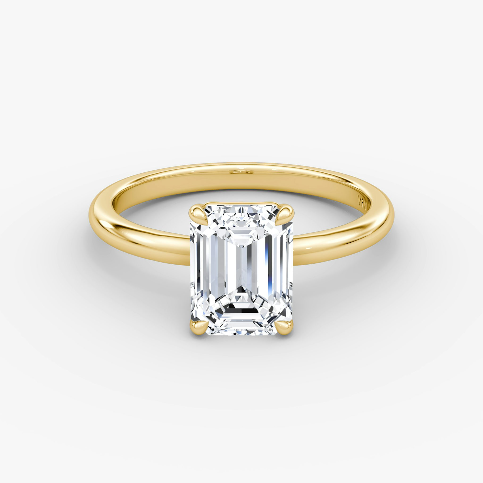 Emerald-cut diamond solitaire engagement ring with a 2.1mm yellow gold band, shown from the front view.