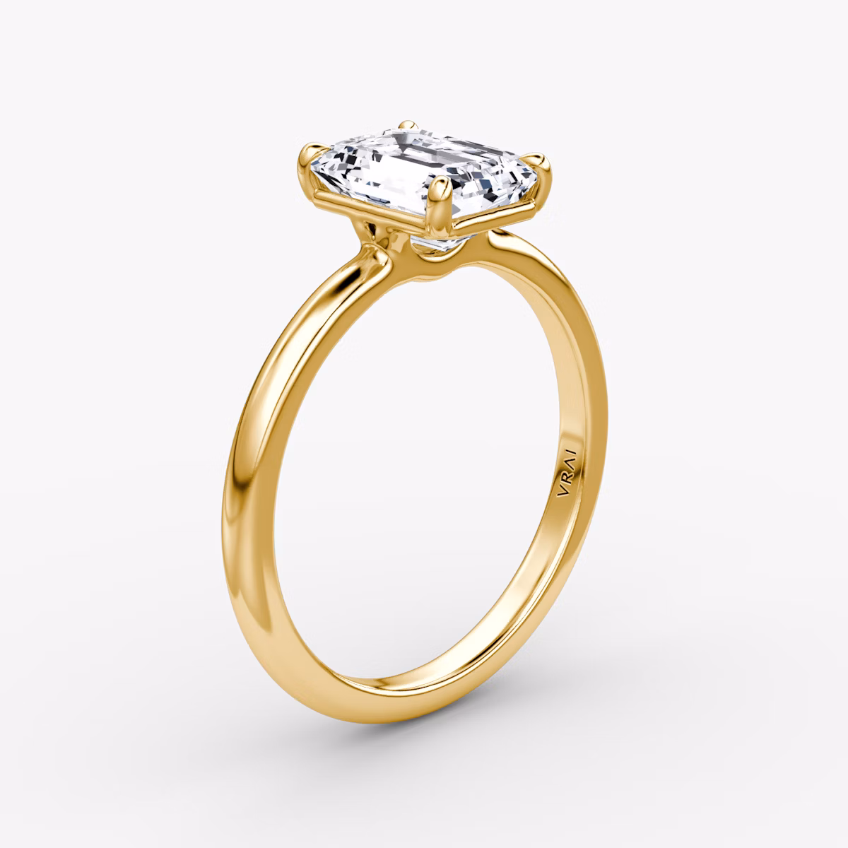 Emerald-cut diamond solitaire engagement ring with a 2.1mm yellow gold band, shown from the front view.