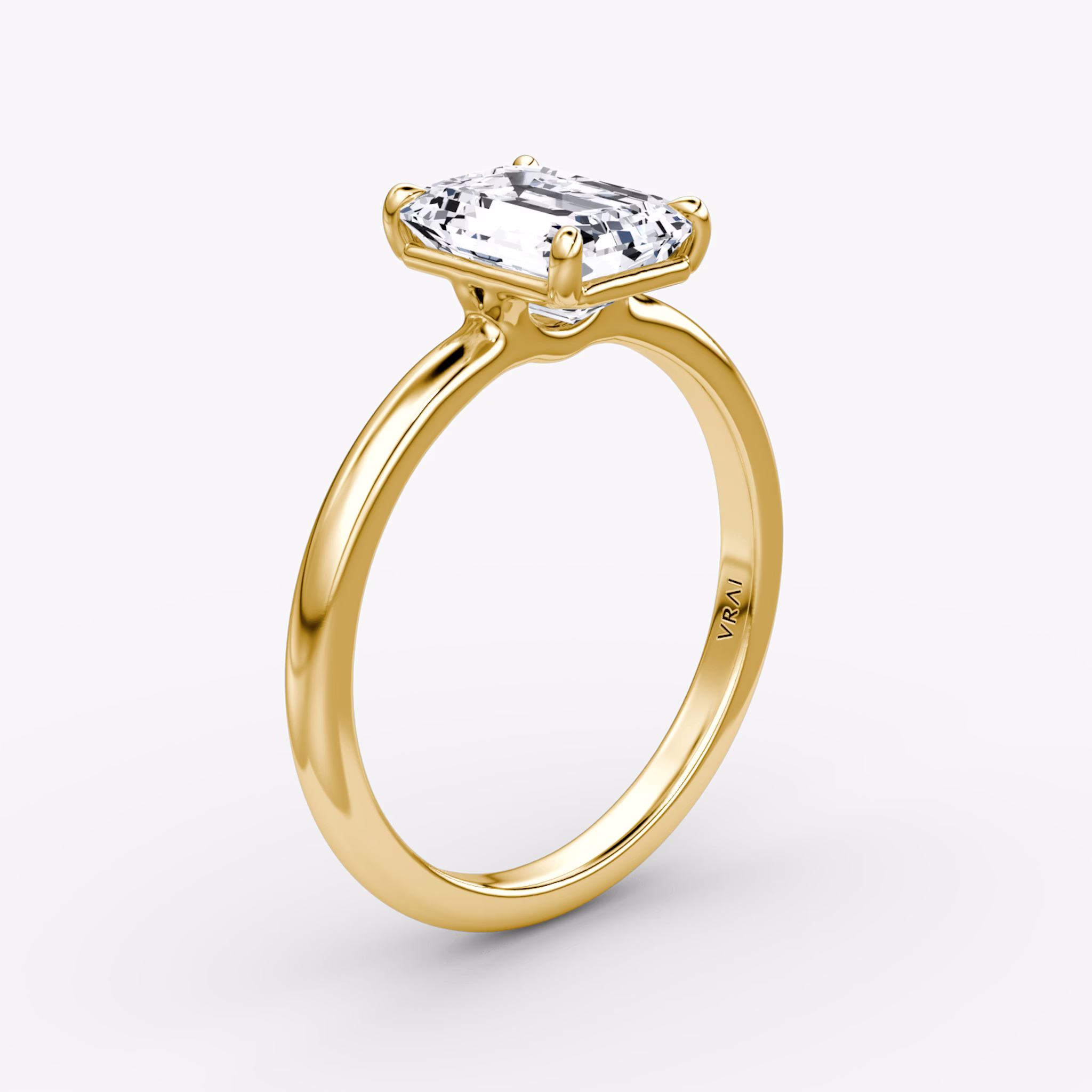 Emerald-cut diamond solitaire engagement ring with a 2.1mm yellow gold band, shown from the front view.