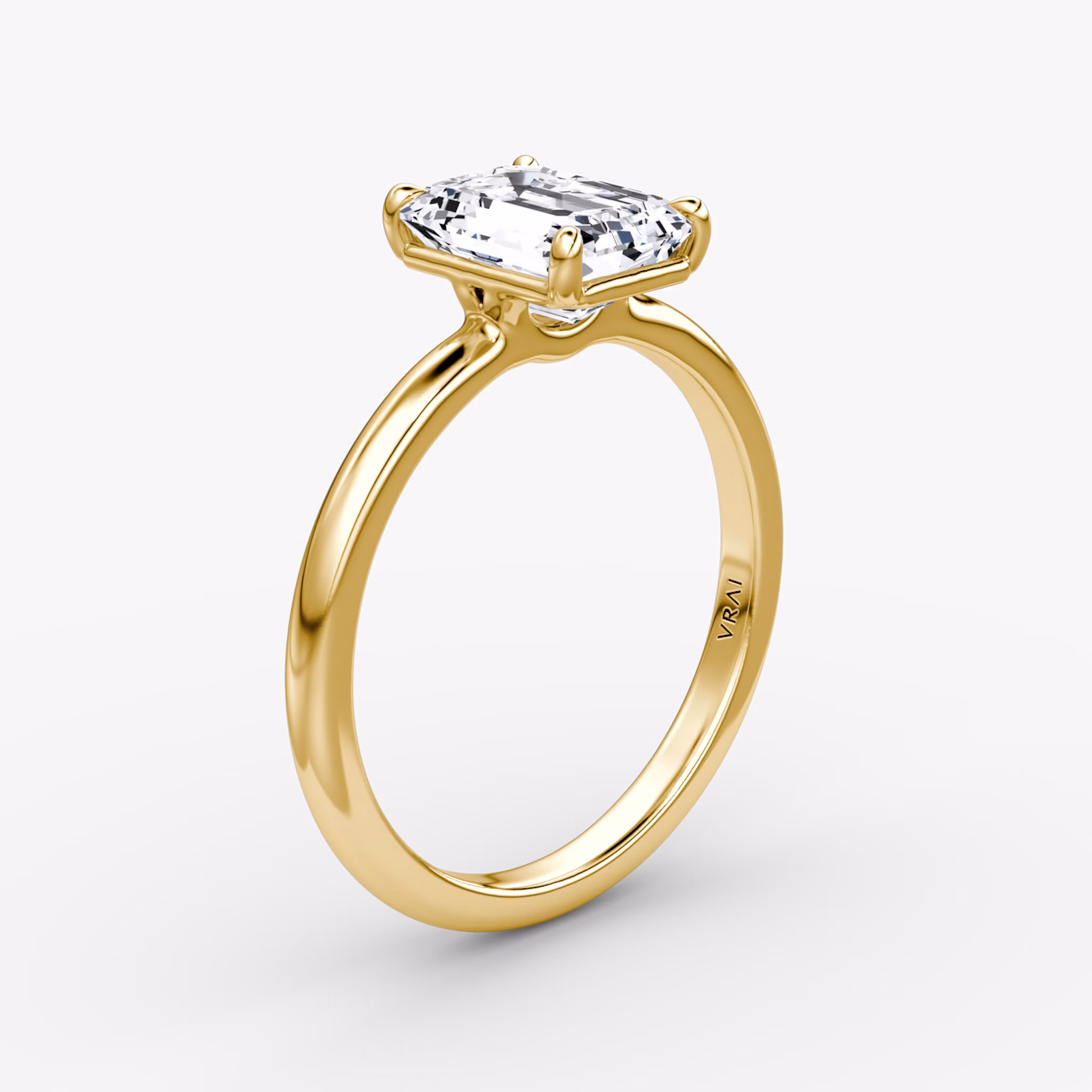 Emerald-cut diamond solitaire engagement ring with a 2.1mm yellow gold band, shown from the front view.