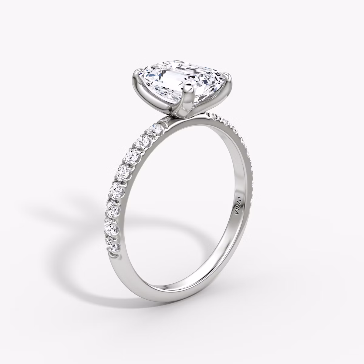 Upright emerald-cut diamond ring with 2.1mm pavé band in white gold, showcasing a classic engagement style with refined brilliance.