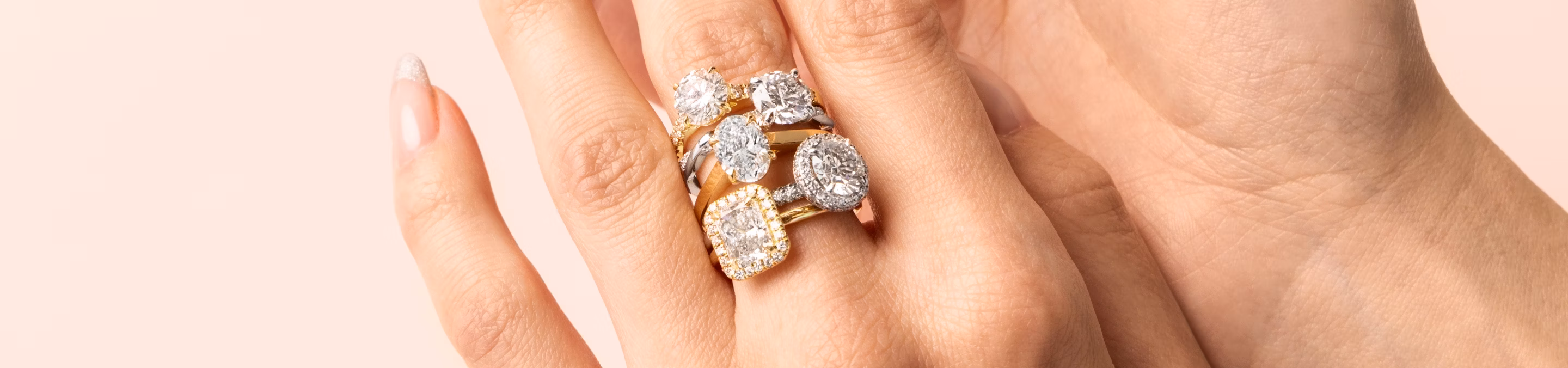 hand showcasing five engagement styles including solitaire, halo, pave and more