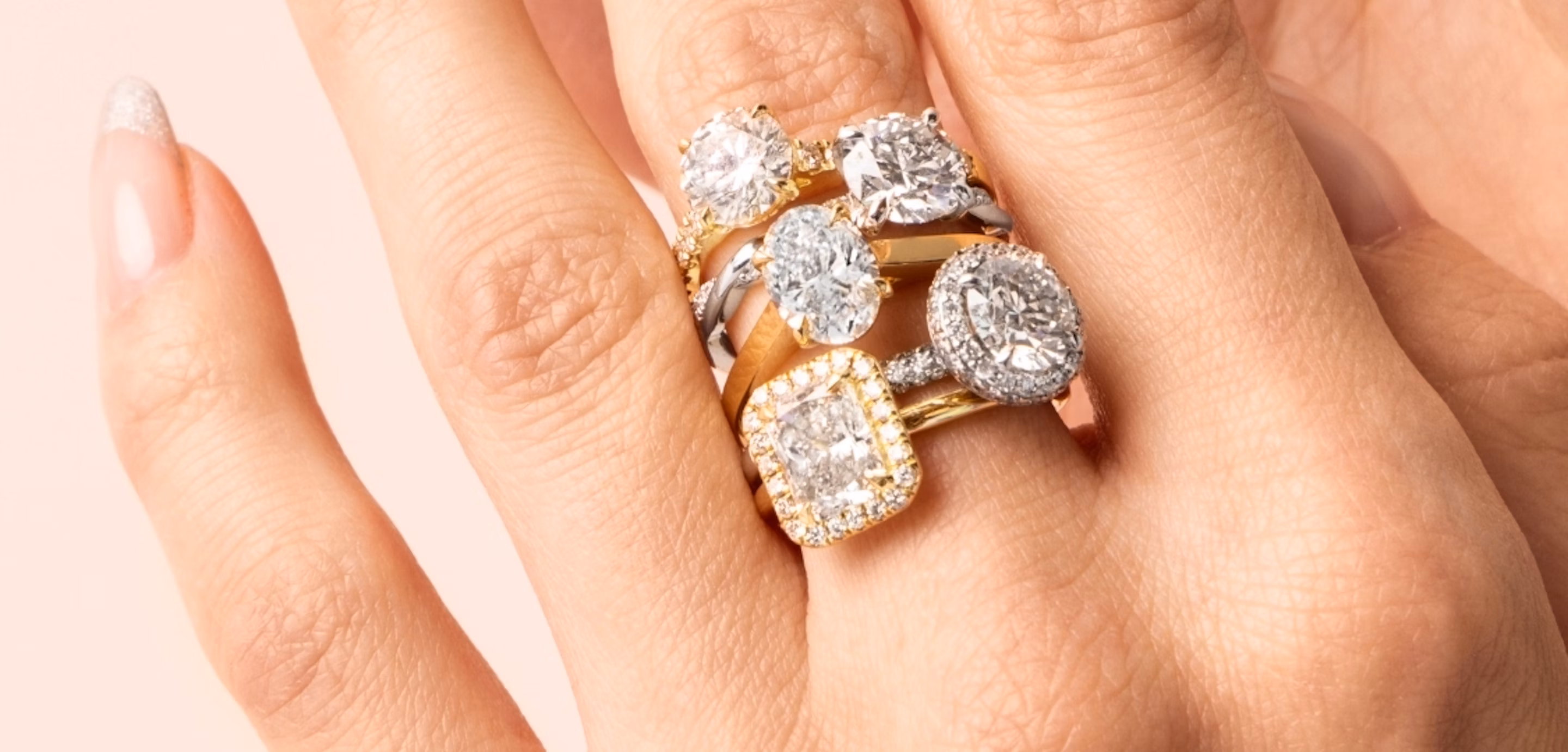 hand showcasing five engagement styles including solitaire, halo, pave and more