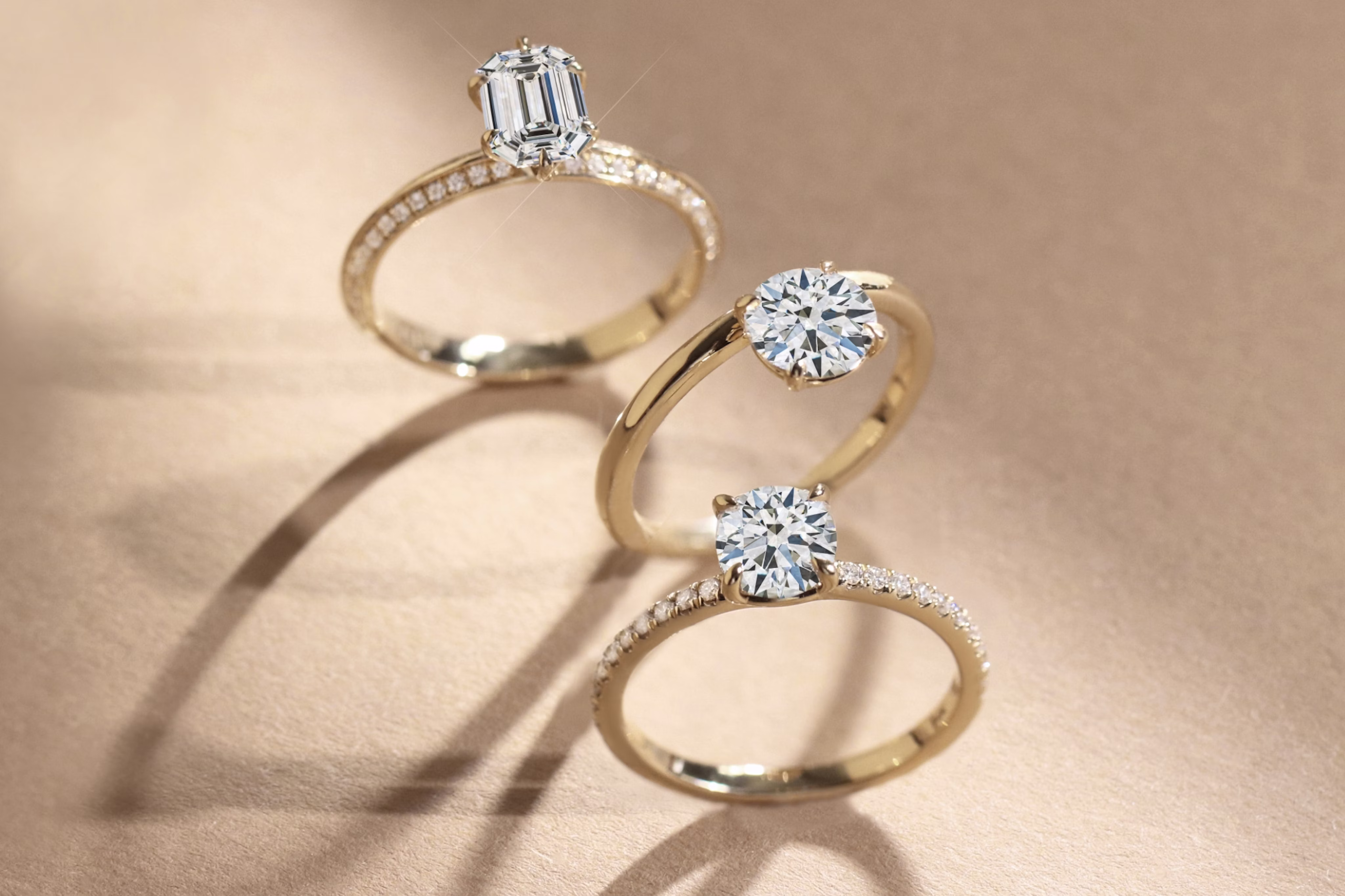 three modern engagement rings with different settings including pave and floating settings