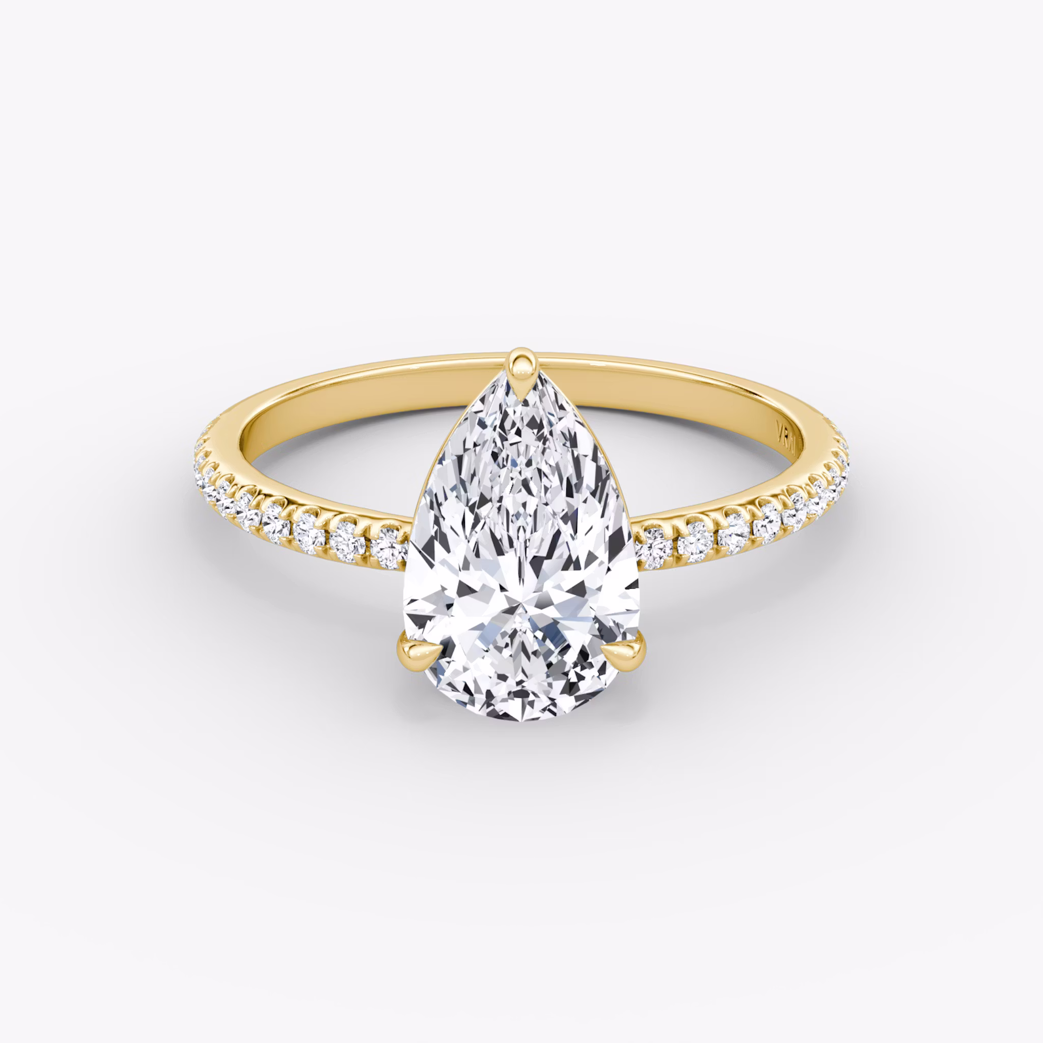 Yellow gold pavé ring with pear-cut center diamond in signature prong setting, shown on white background.
