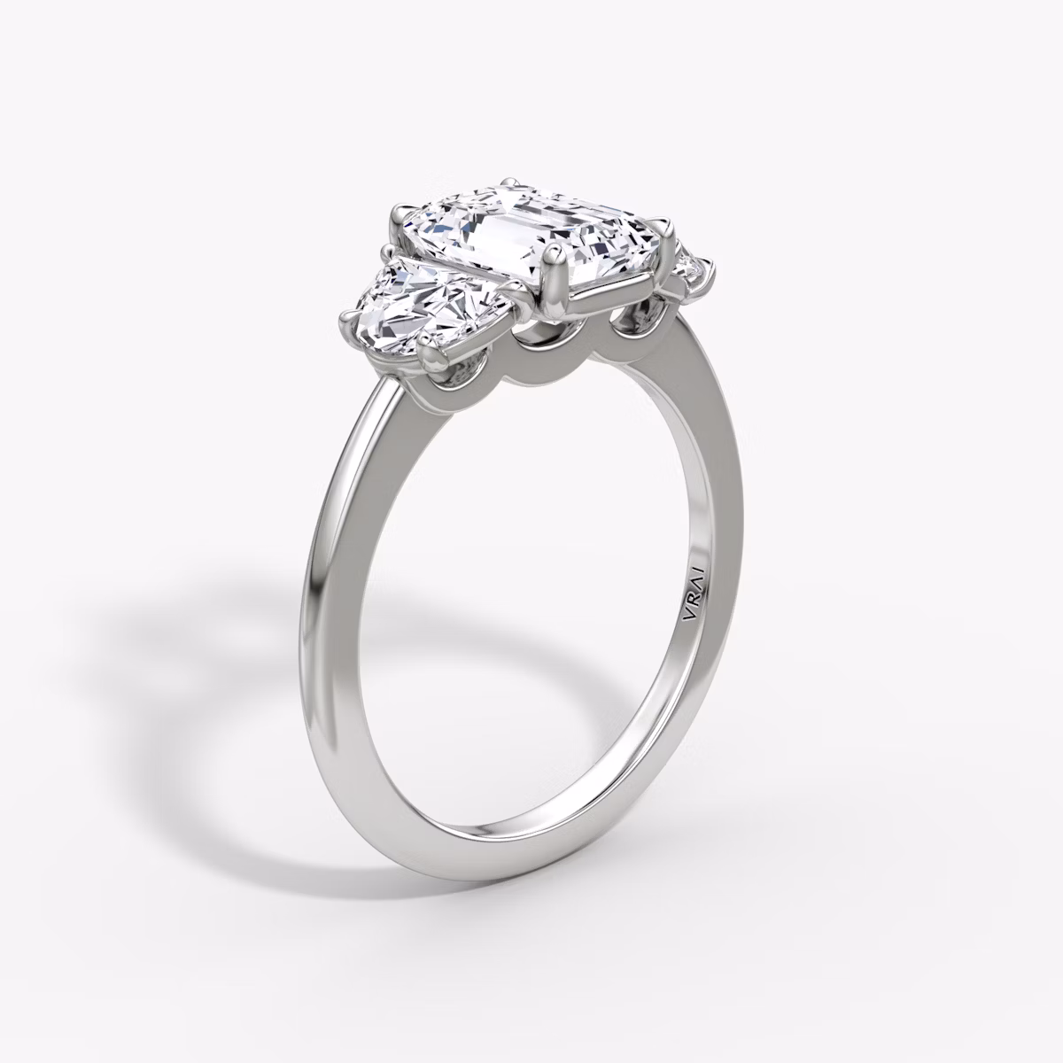 The Three Stone | Emerald | Platinum | bandAccent: Plain | sideStoneCarat: 0.50ct | sideStoneShape: Half Moon | diamondOrientation: vertical | caratWeight: other