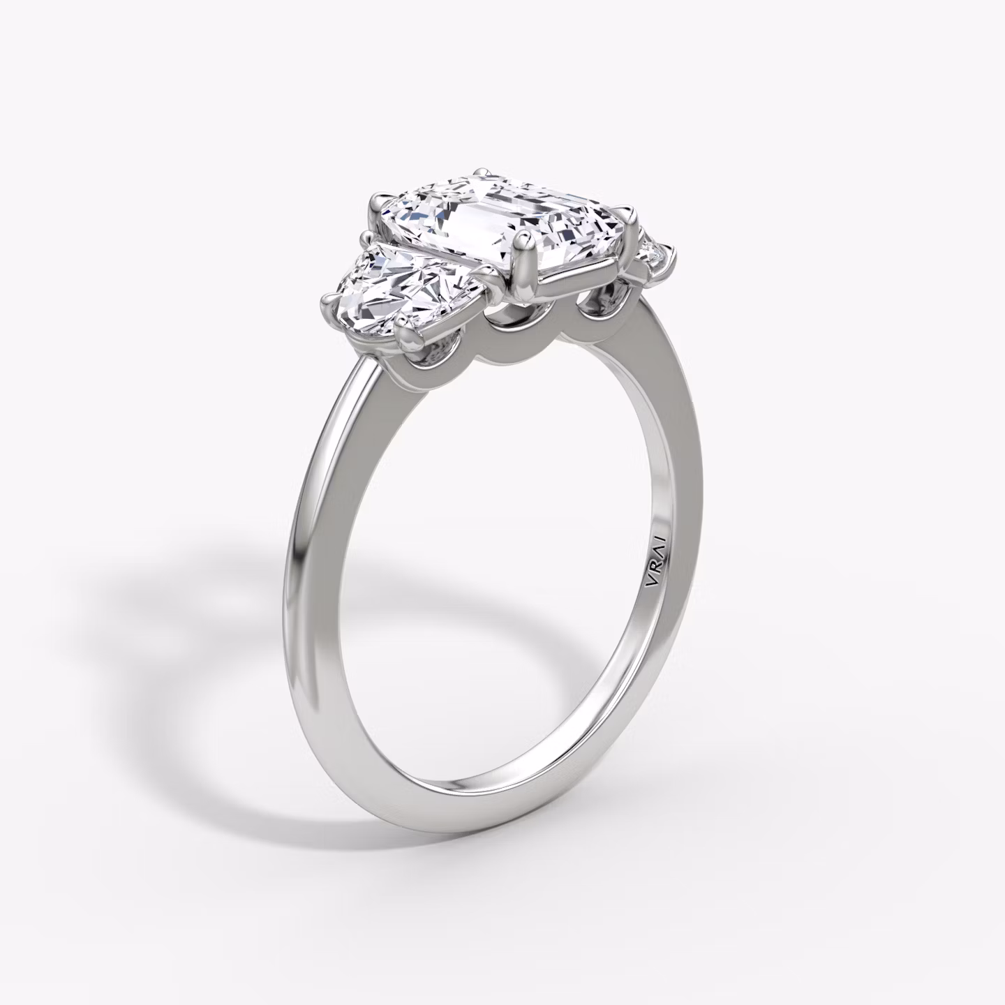 The Three Stone | Emerald | Platinum | bandAccent: Plain | sideStoneCarat: 0.50ct | sideStoneShape: Half Moon | diamondOrientation: vertical | caratWeight: other