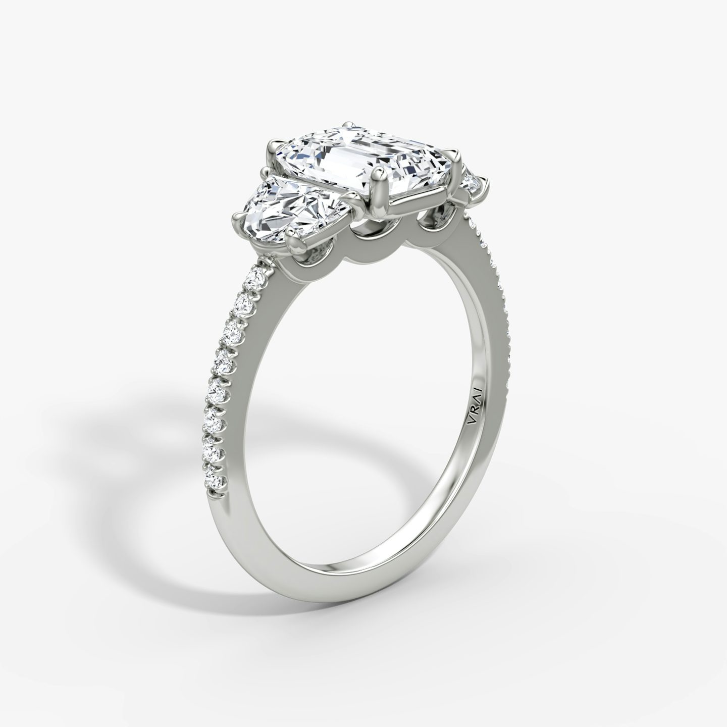 The Three Stone | Emerald | Platinum | bandAccent: Pavé | sideStoneCarat: 0.50ct | sideStoneShape: Half Moon | diamondOrientation: vertical | caratWeight: other