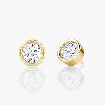 Three-quarter view of round bezel-set solitaire stud earring in yellow gold, 1.00 ct design.