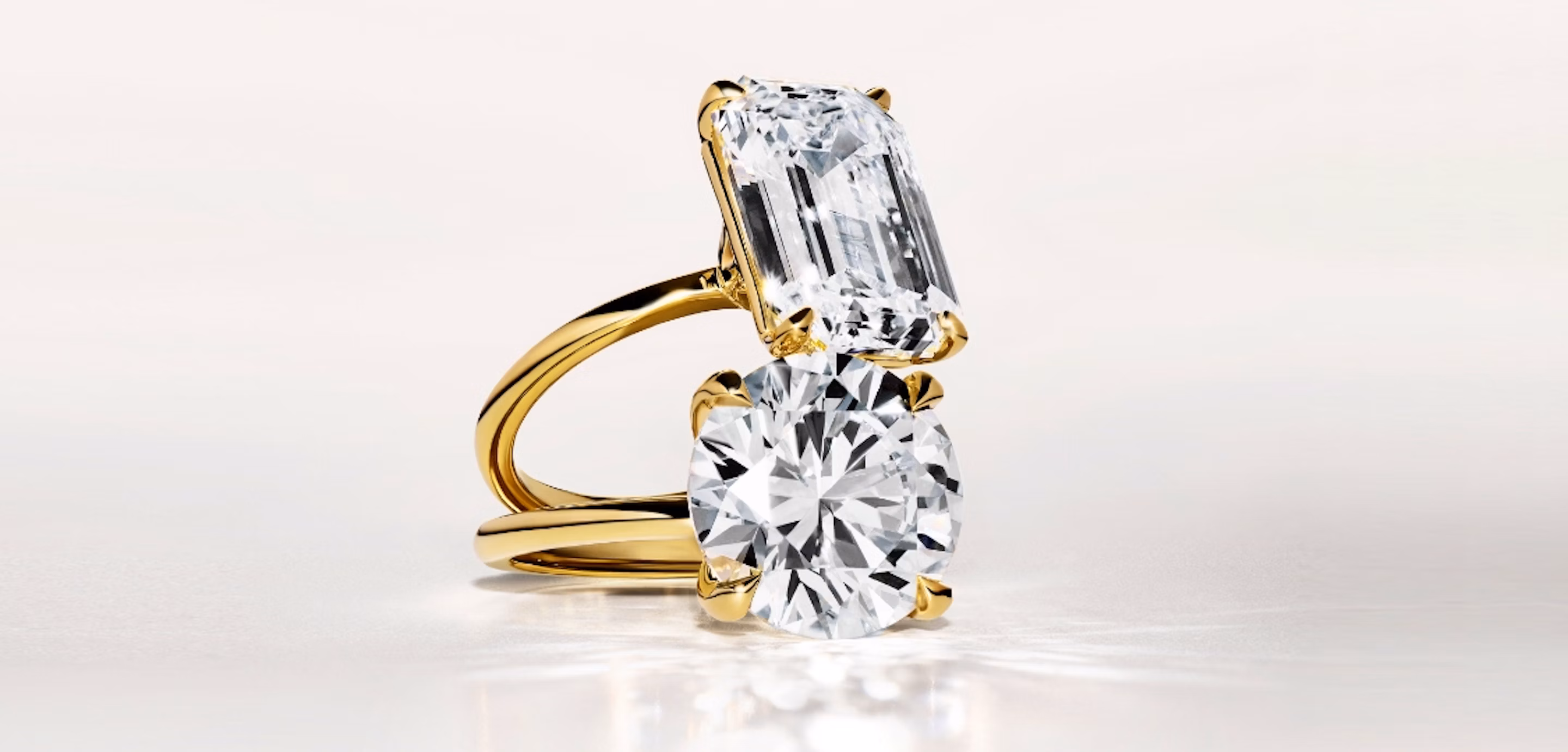 two engagement rings in yellow gold with an emerald cut and a round brilliant cut