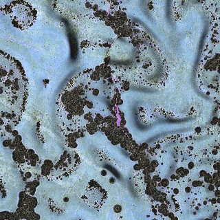 An abstract, textured surface featuring pale blue hues with irregular, jagged edges highlighted in vibrant purple, blue, and black.
