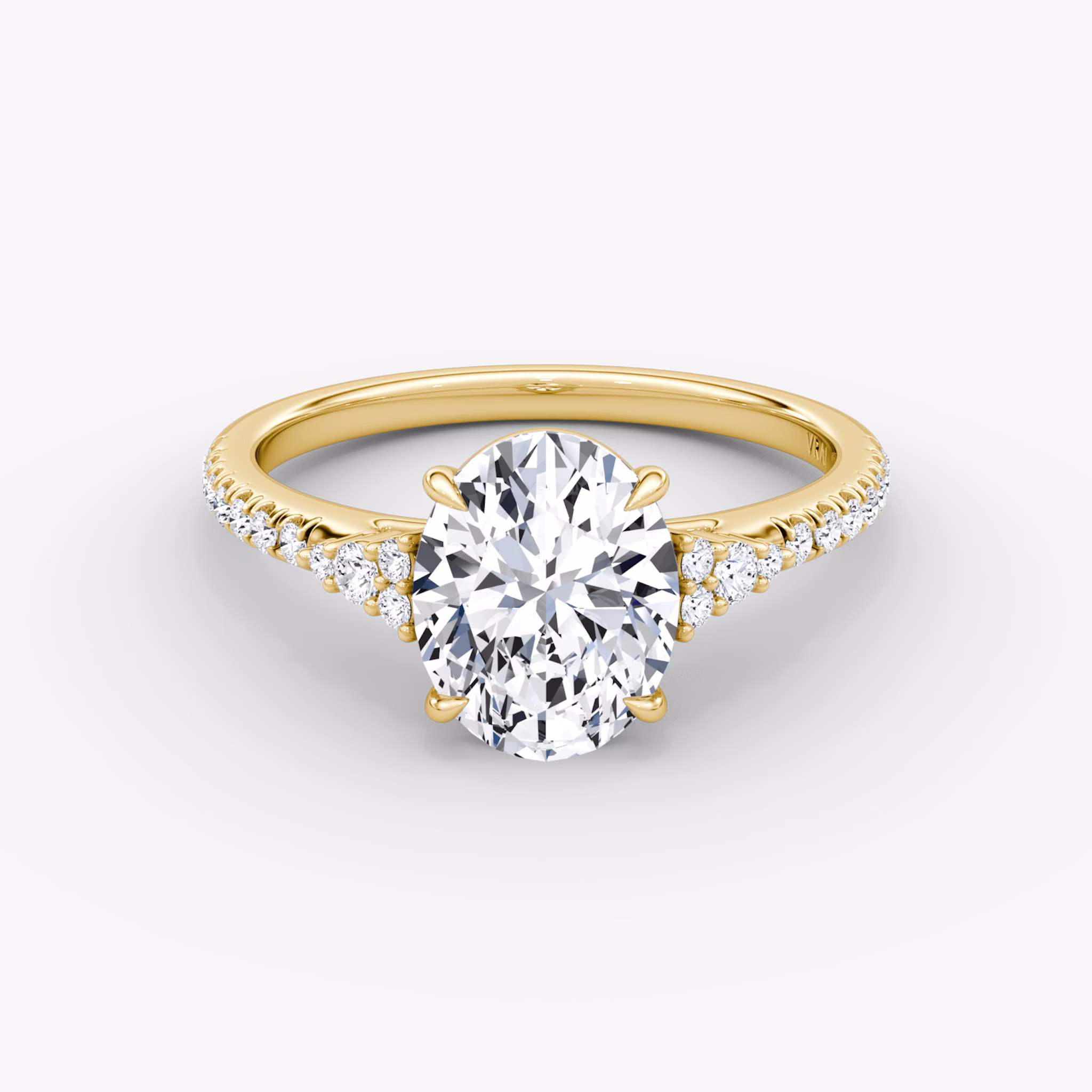 A close-up image of VRAI's Side Cluster Cathedral Oval Yellow Gold Engagement Ring, lying flat.