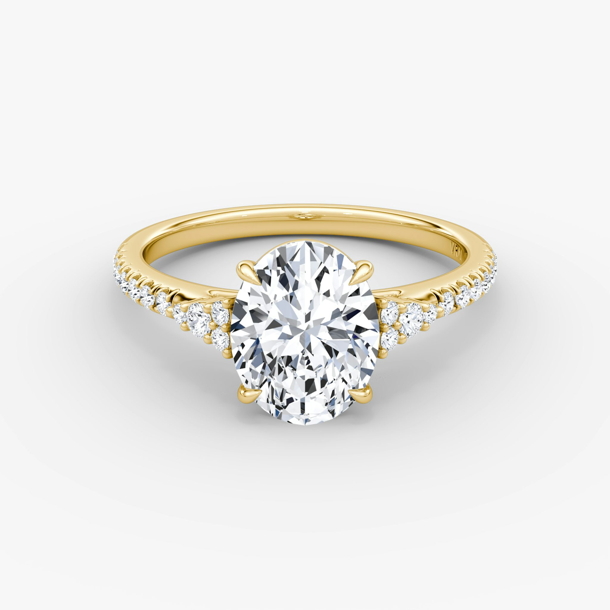 A close-up image of VRAI's Side Cluster Cathedral Oval Yellow Gold Engagement Ring, lying flat.