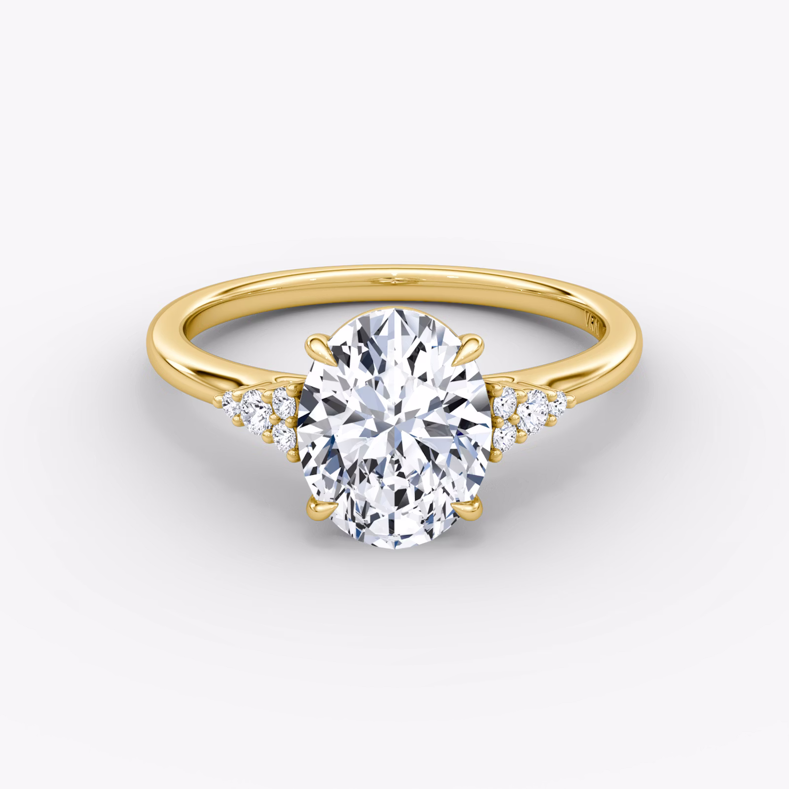 A close-up image of VRAI's Side Cluster Cathedral Oval Yellow Gold Engagement Ring, lying flat.