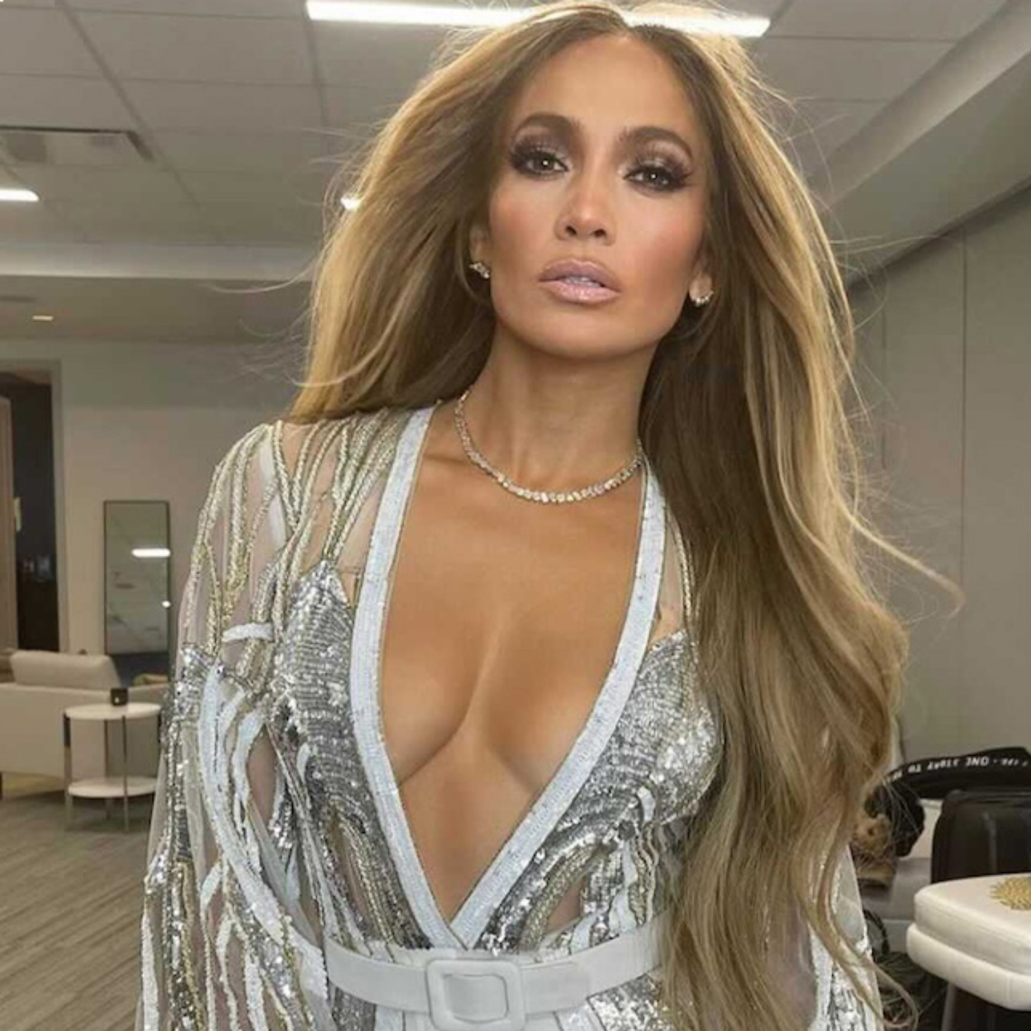 An image of Jennifer Lopez wearing a VRAI necklace, in a gold and silver sequin outfit.