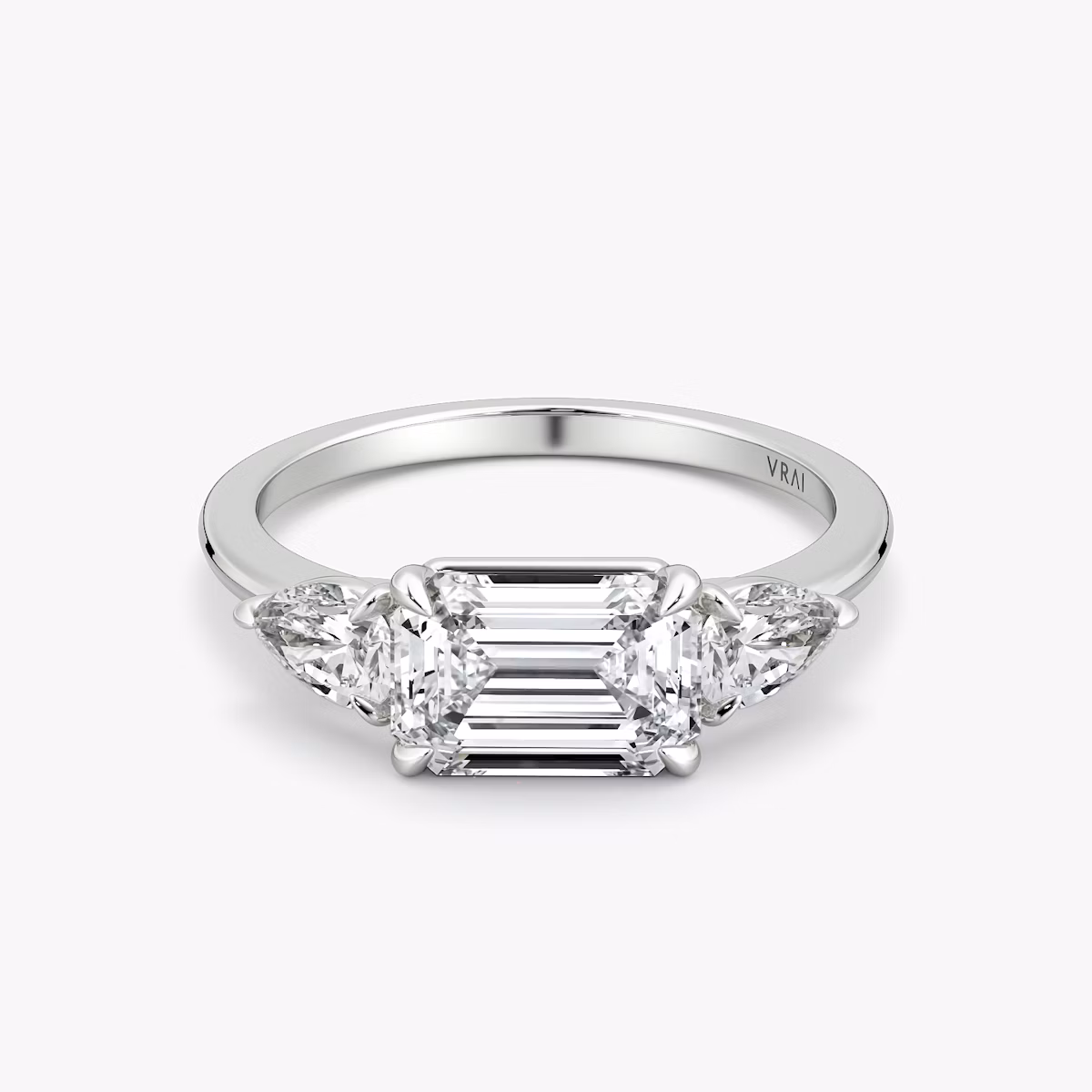 The Three Stone | Emerald | 18k | White Gold | bandAccent: Plain | diamondOrientation: horizontal | sideStoneCarat: 0.25ct | sideStoneShape: Pear | caratWeight: other